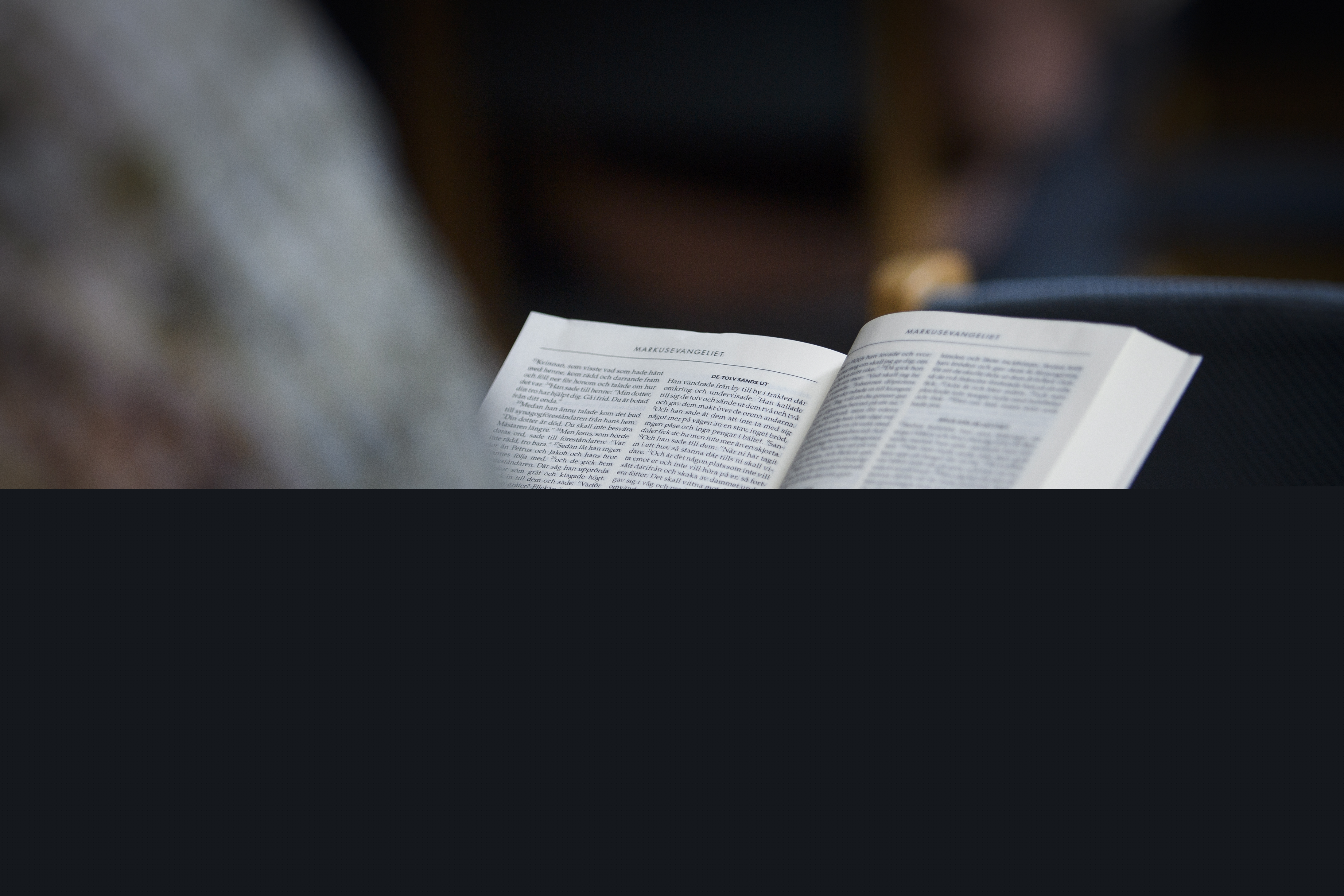 En person sitter och läser bibeln.