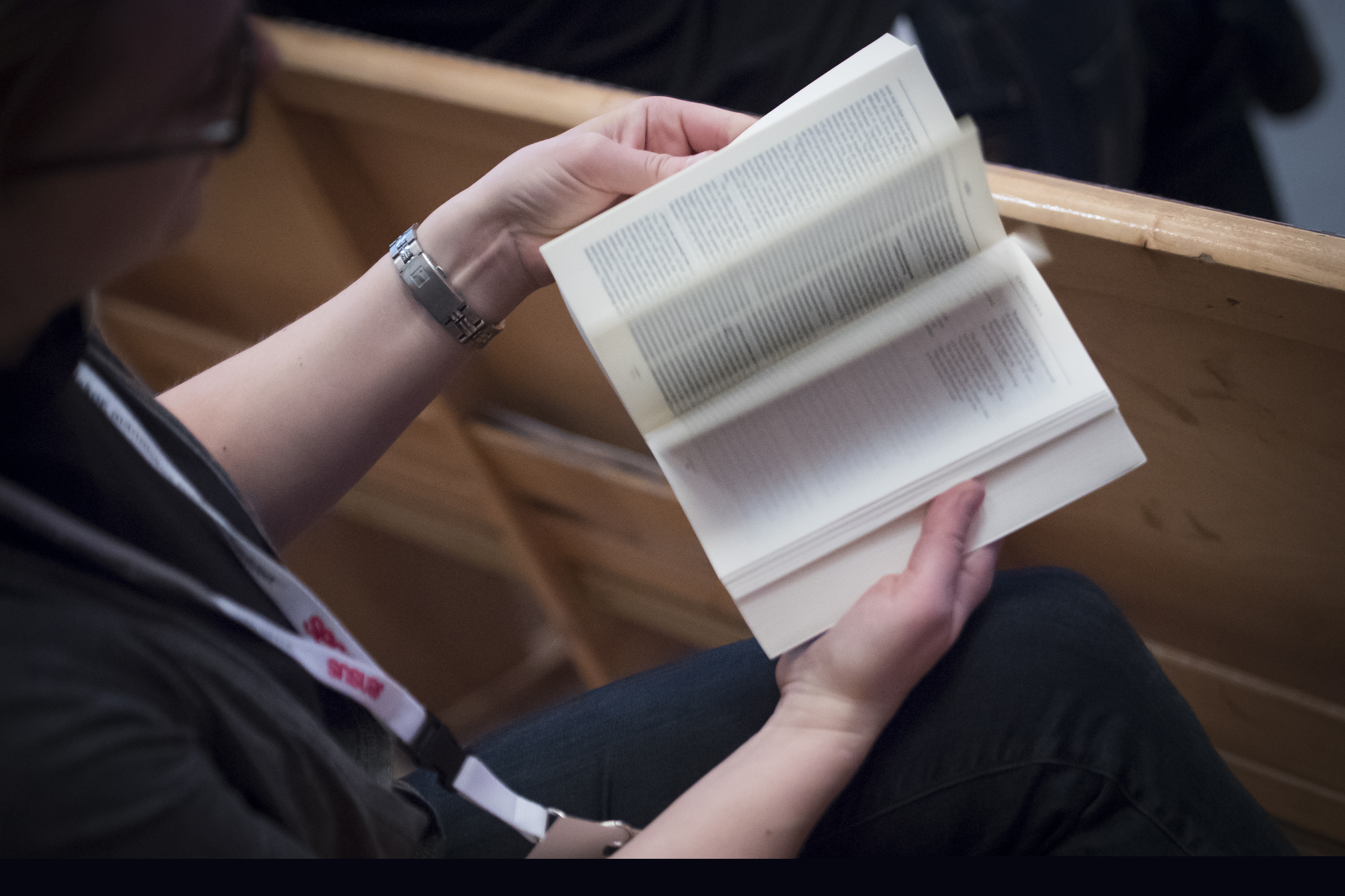 En person sitter och bläddrar i en bibel.