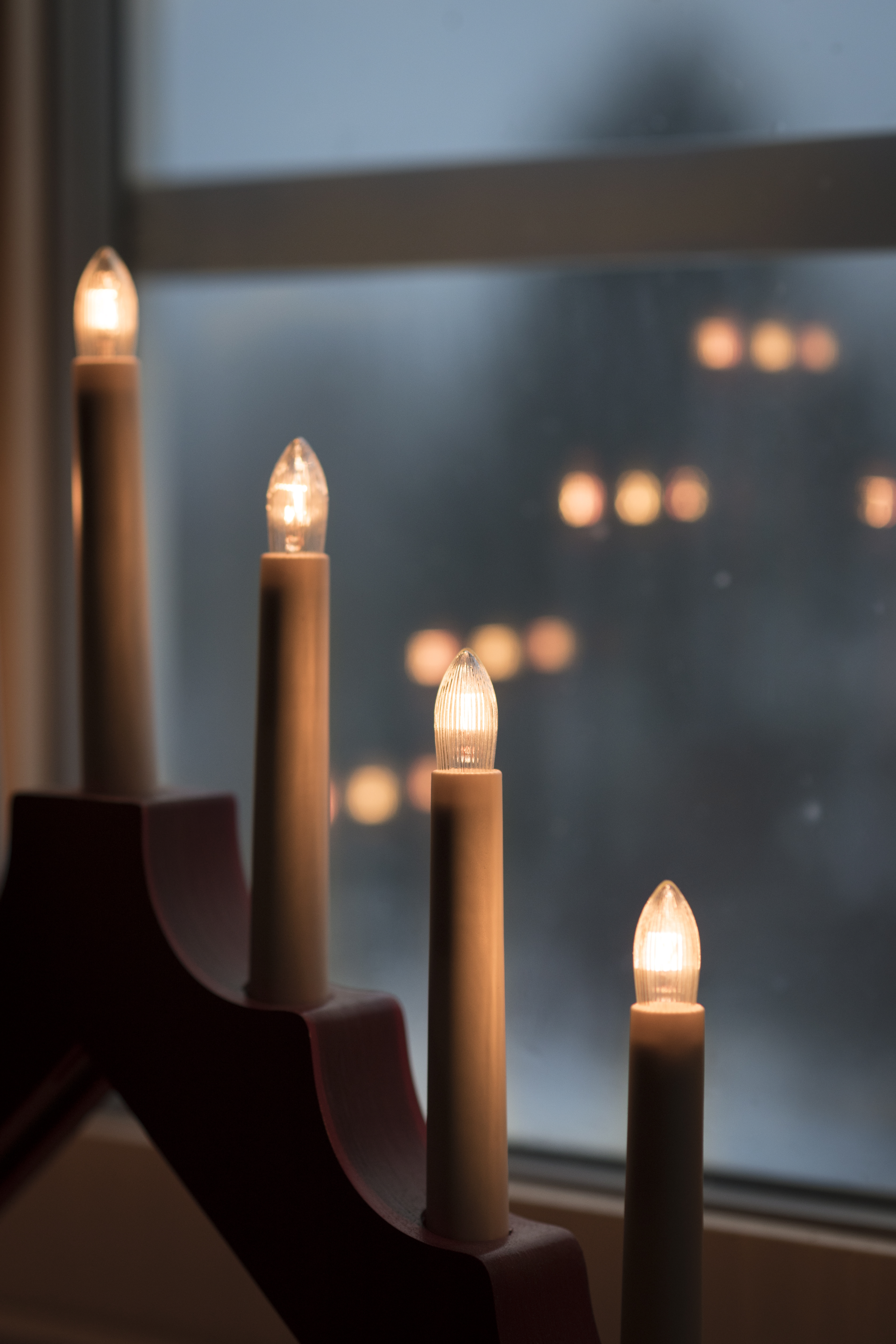 Närbild på en adventsljusstake i ett fönster.