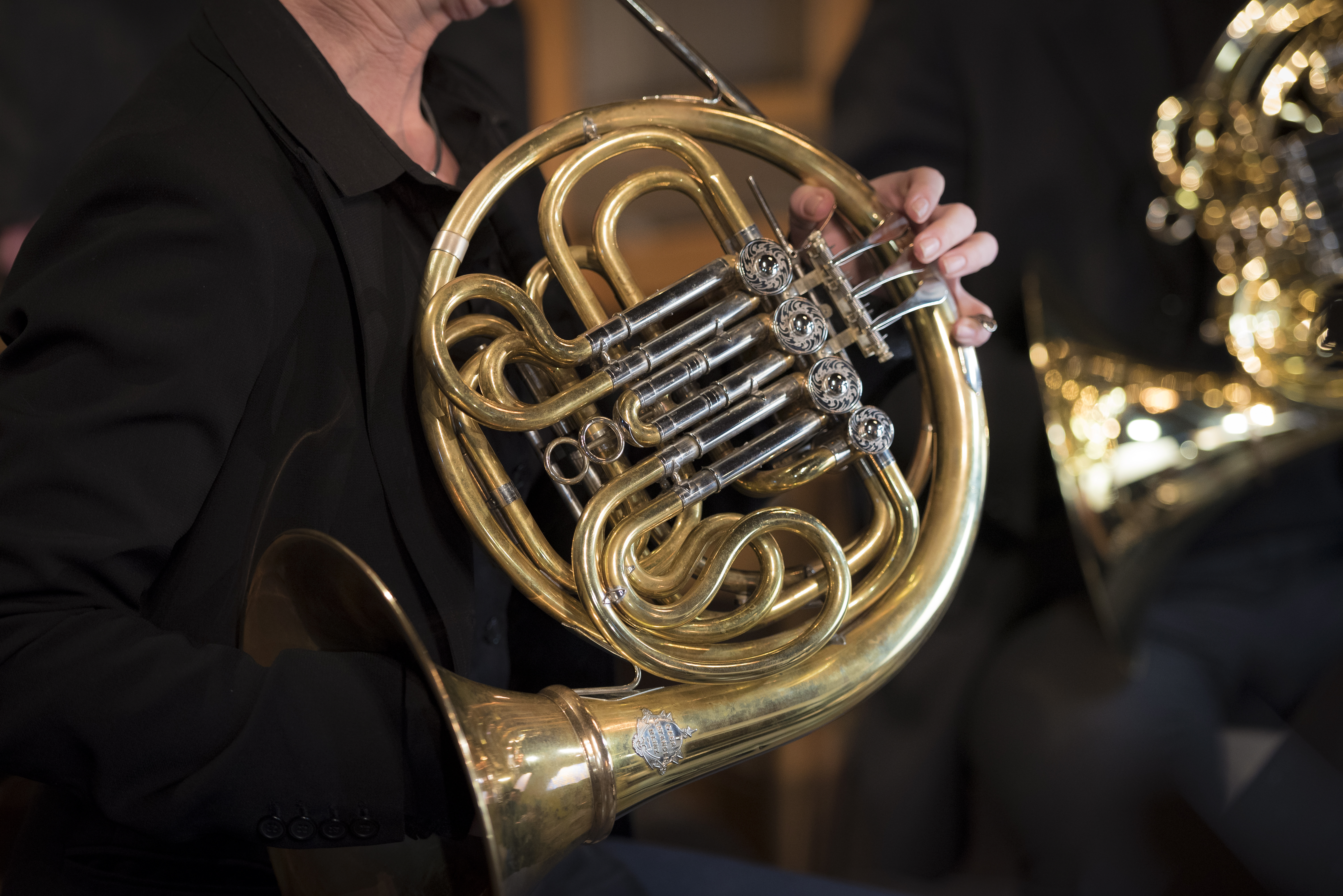 En person spelar valthorn.