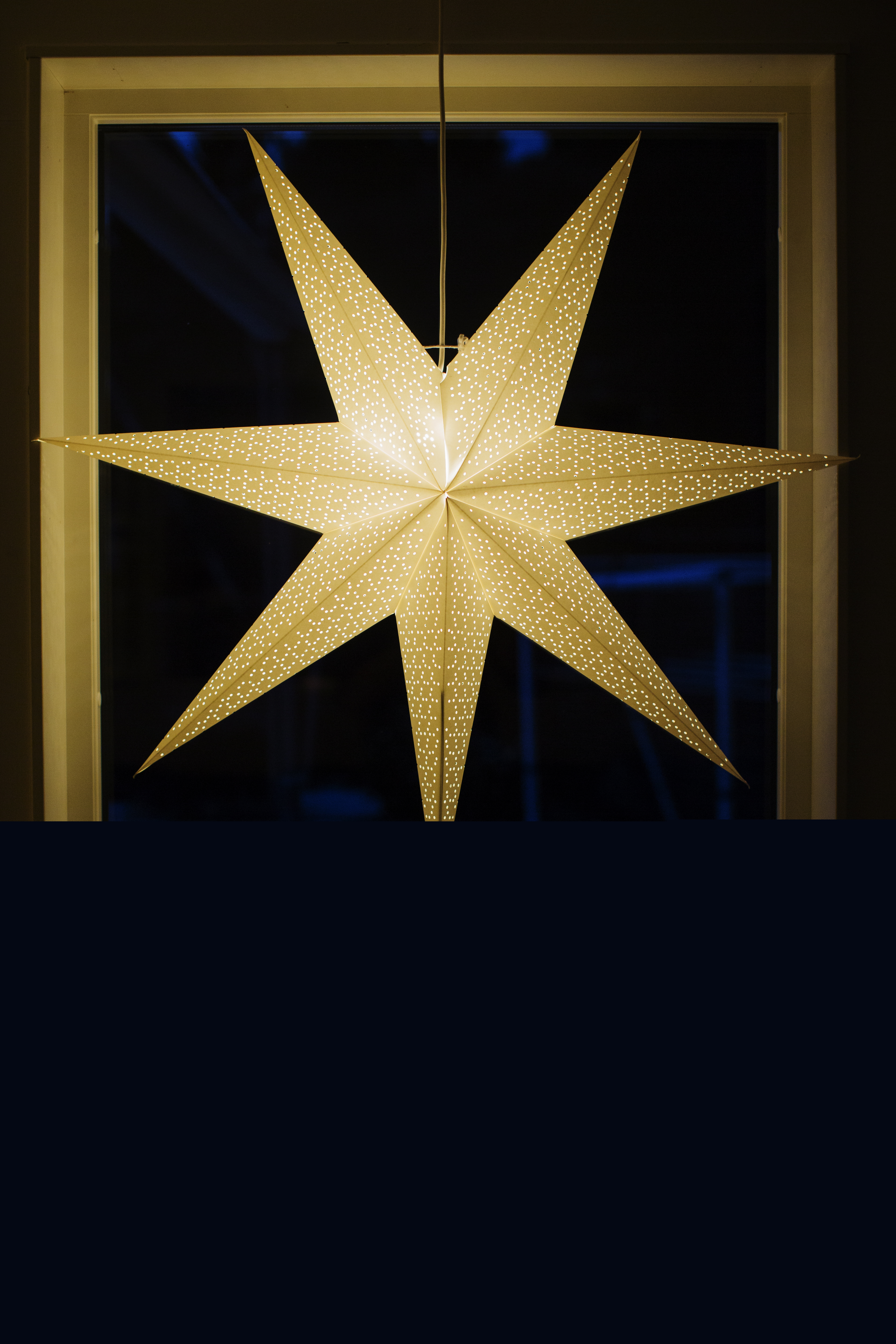 En adventsstjärna lyser i ett fönster.