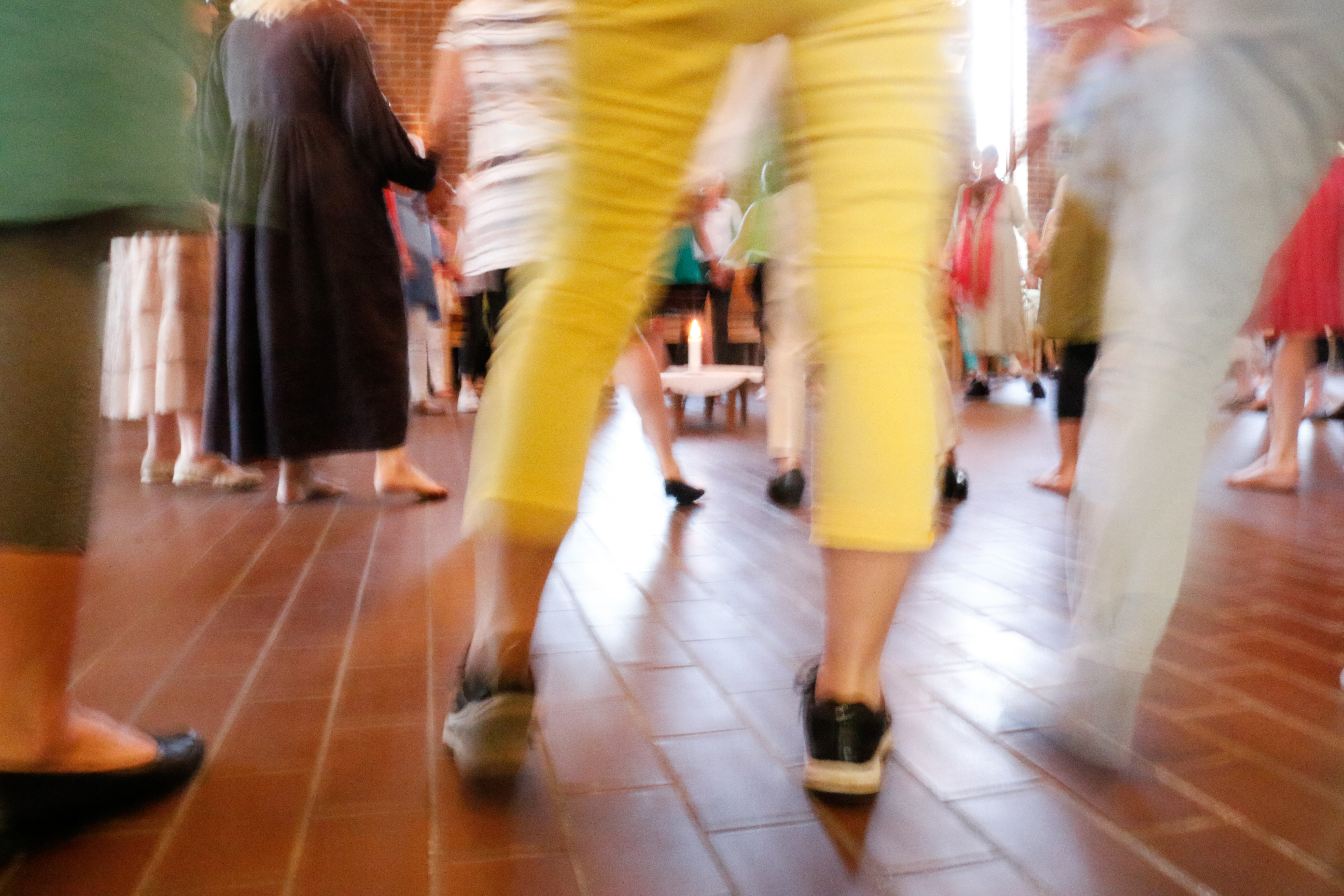 Suddig bild av en grupp människor i rörelse inomhus.