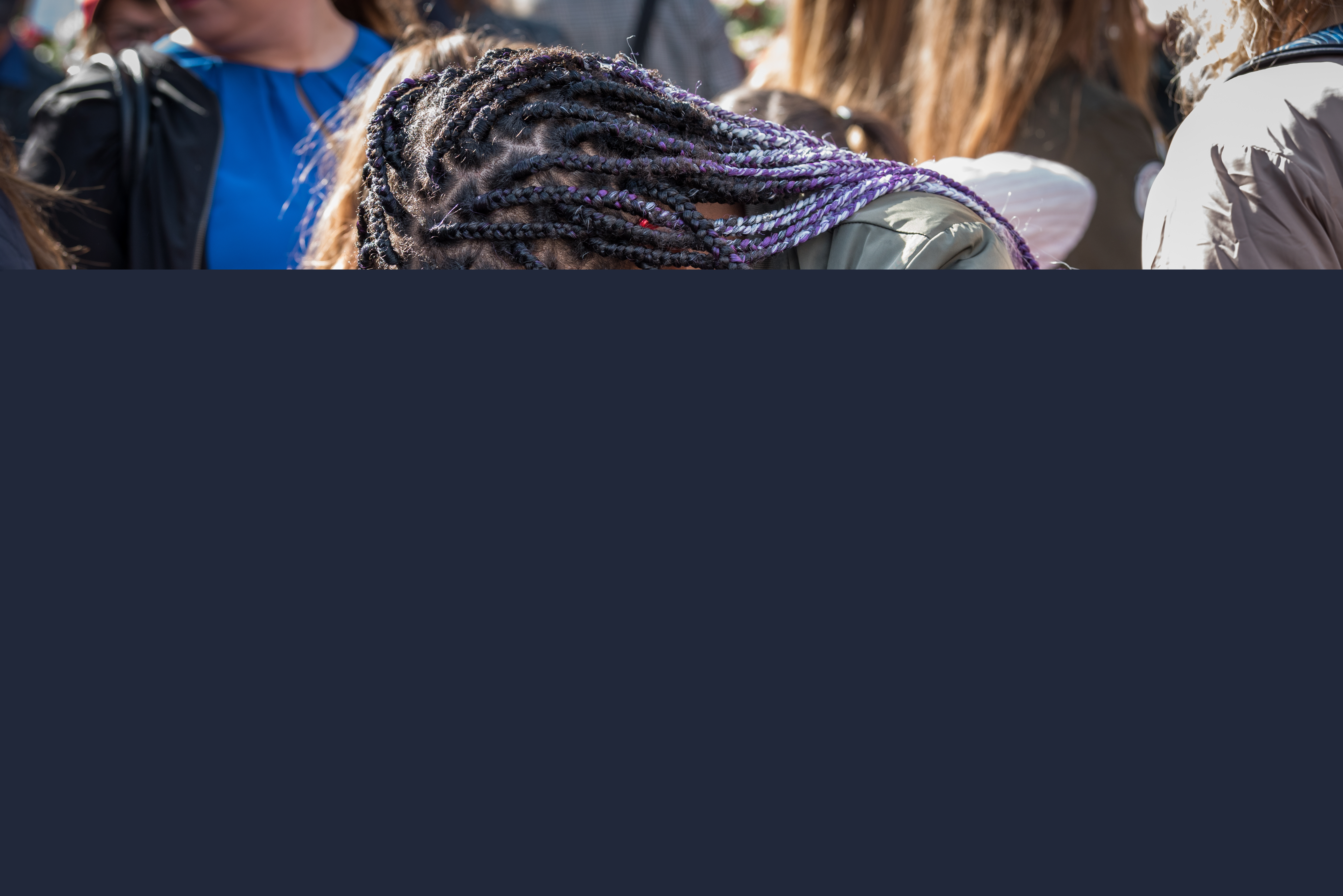 Två flickor i en folkmassa kramar om varandra hårt.