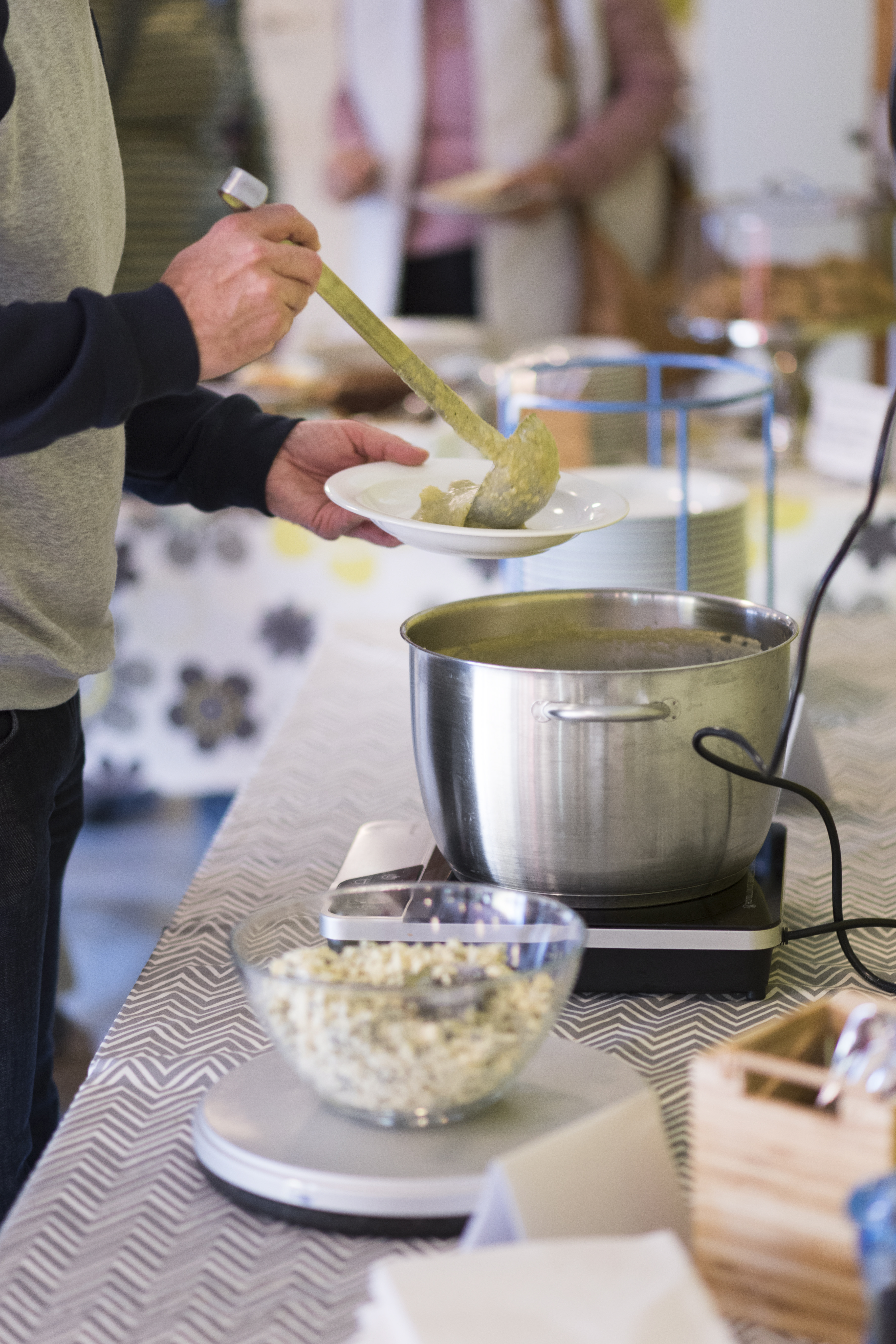 Någon slevar upp soppa i en skål.