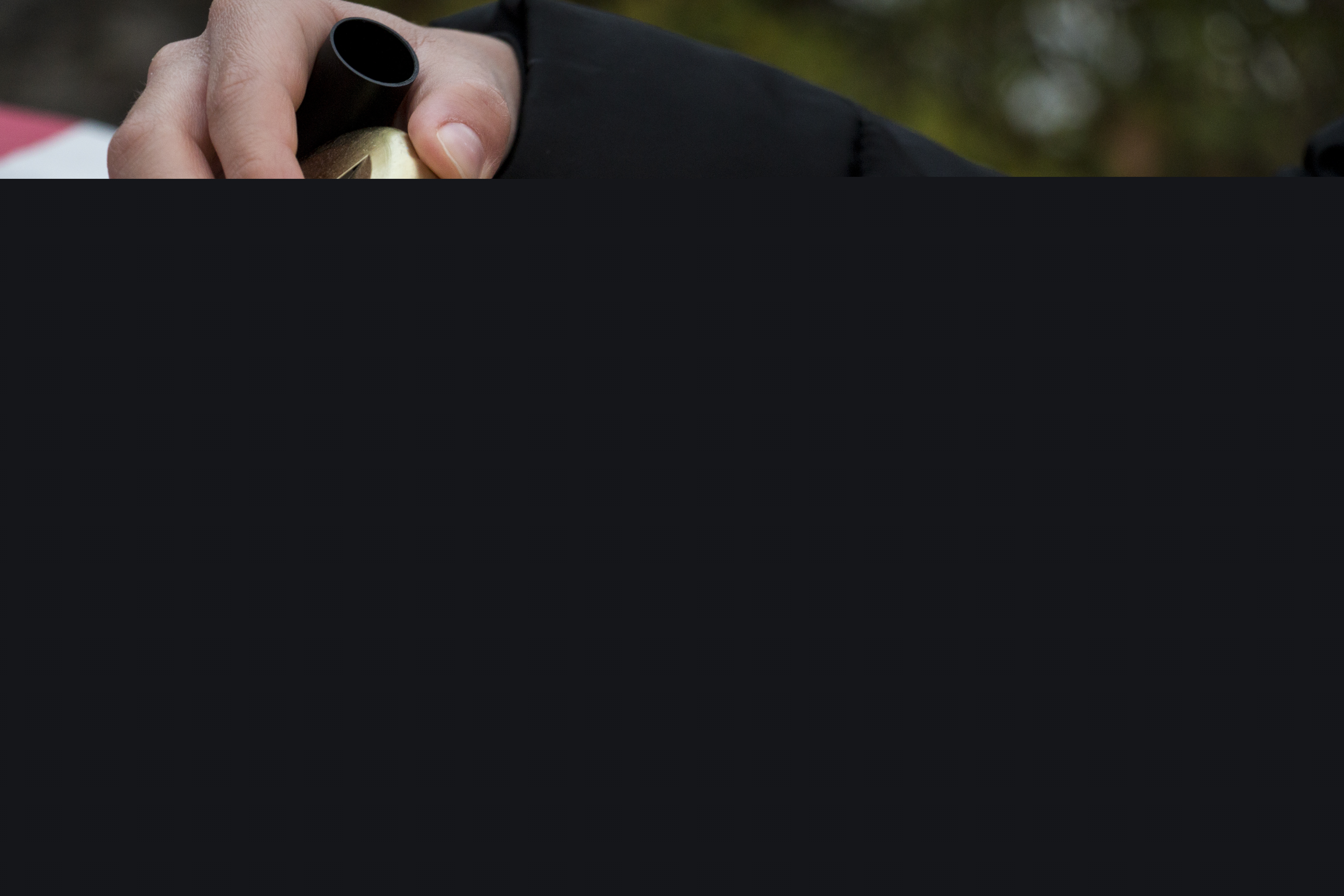 Ett barn skriver en hälsning till sin morfar på ett gravljus.