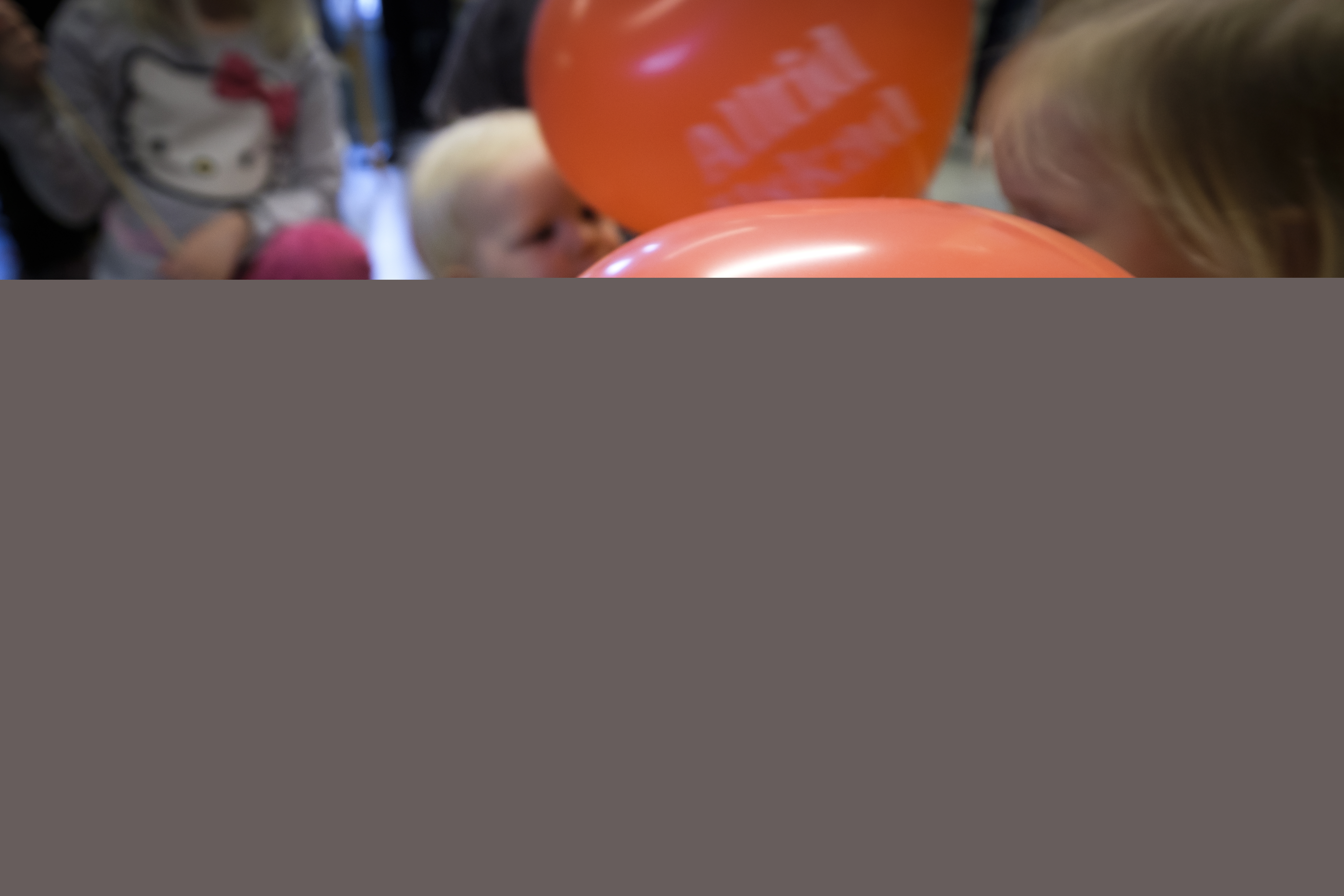 Några små barn med röda ballonger med texten Alltid älskad.