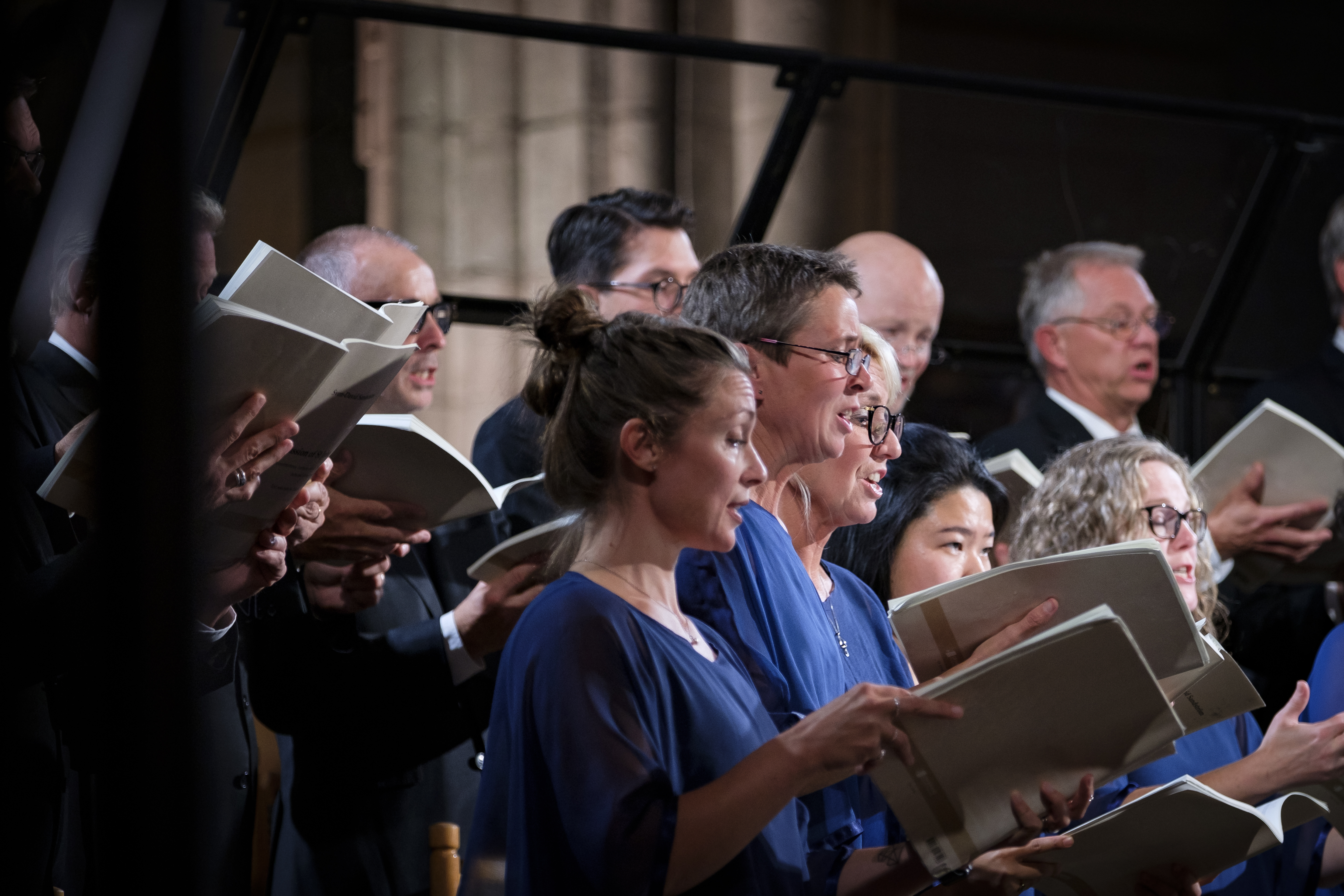 En blandad kyrkokör i matchande blå färger sjunger i Uppsala domkyrka.