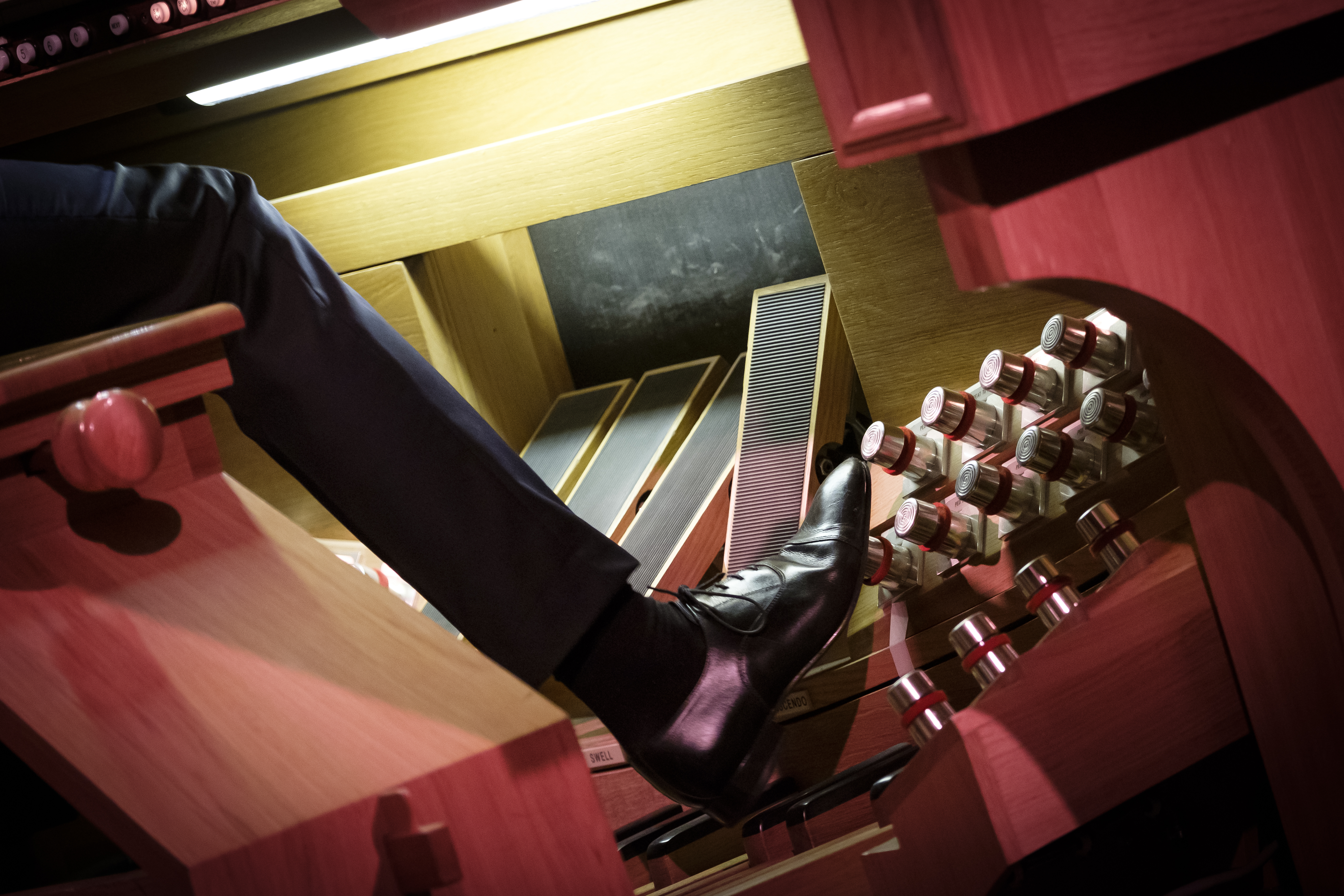 En kyrkoorganist använder orgelns fotpedaler.