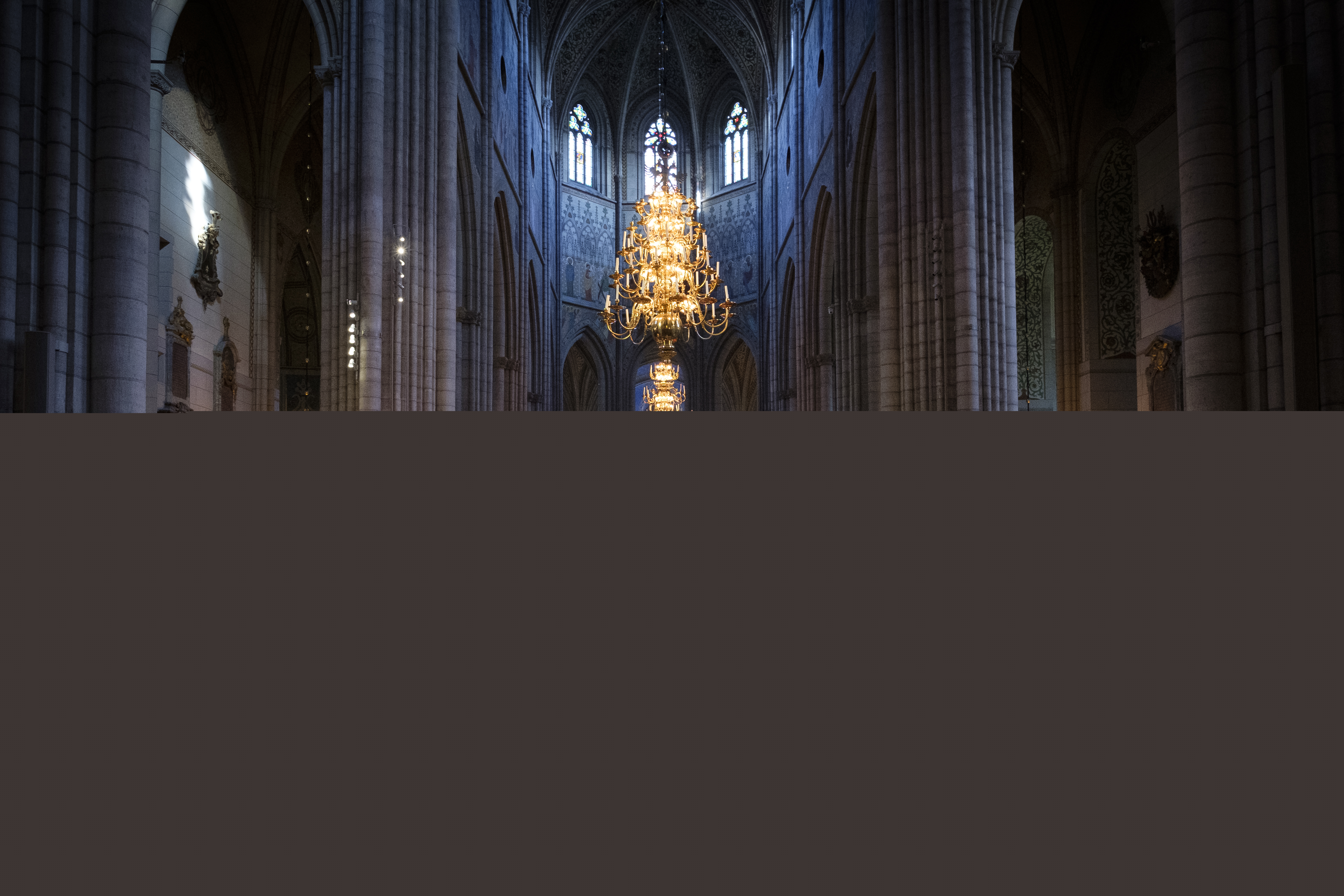 Uppsala domkyrkas gosskör i rödgula och blåa kåpor sjunger i en fullsatt domkyrka.
