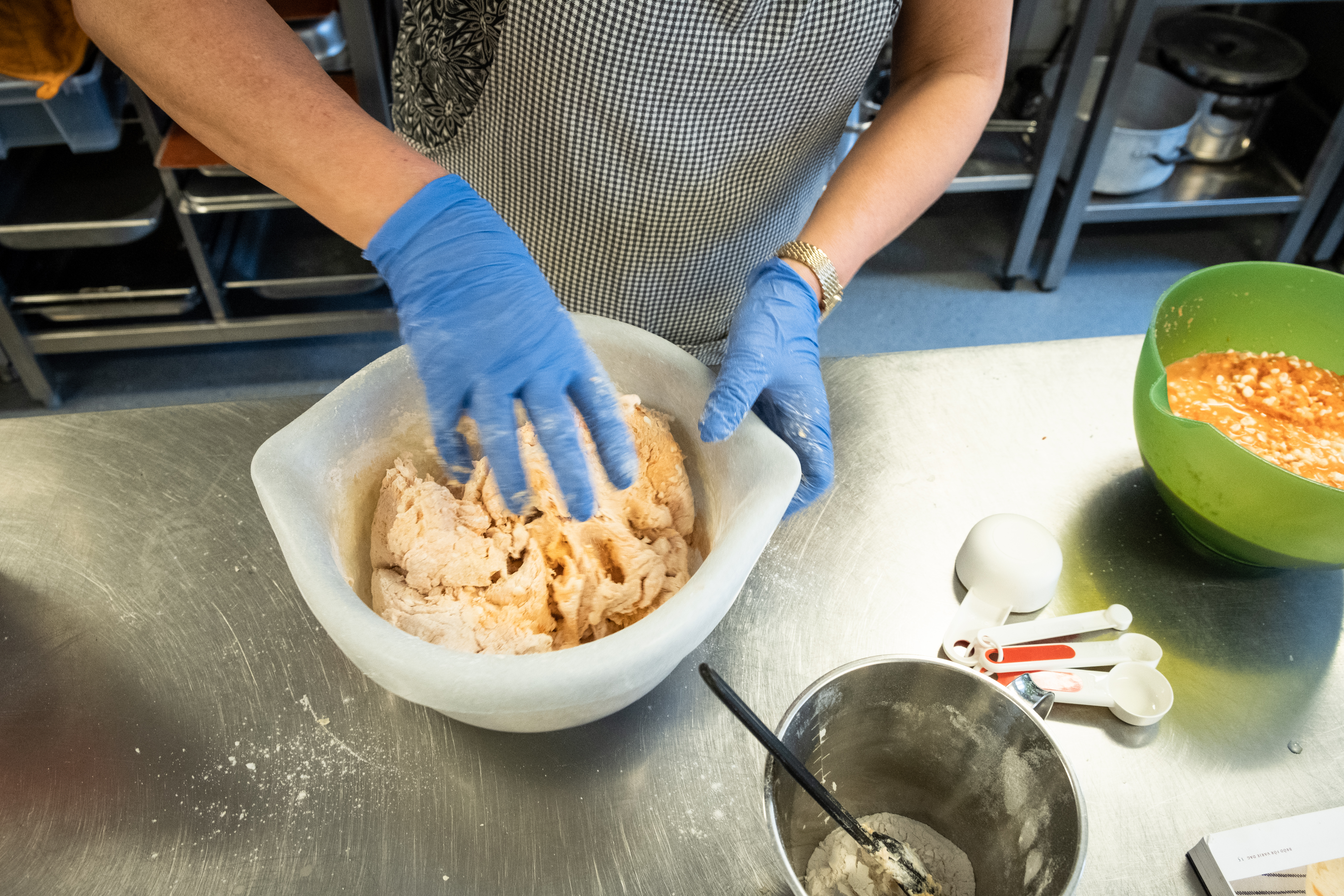 Någon knådar en deg i en bunke.