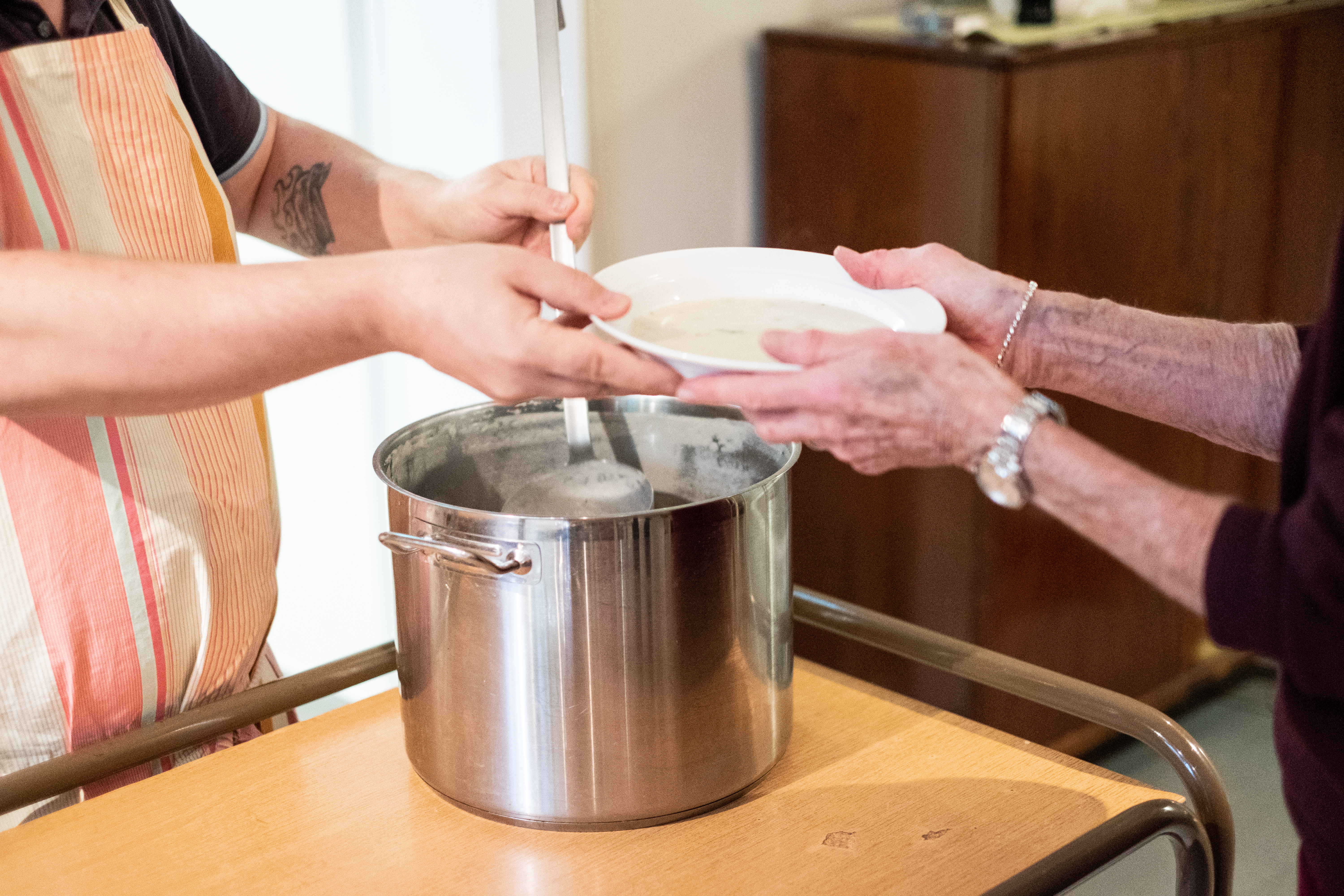 Någon står och serverar soppa.