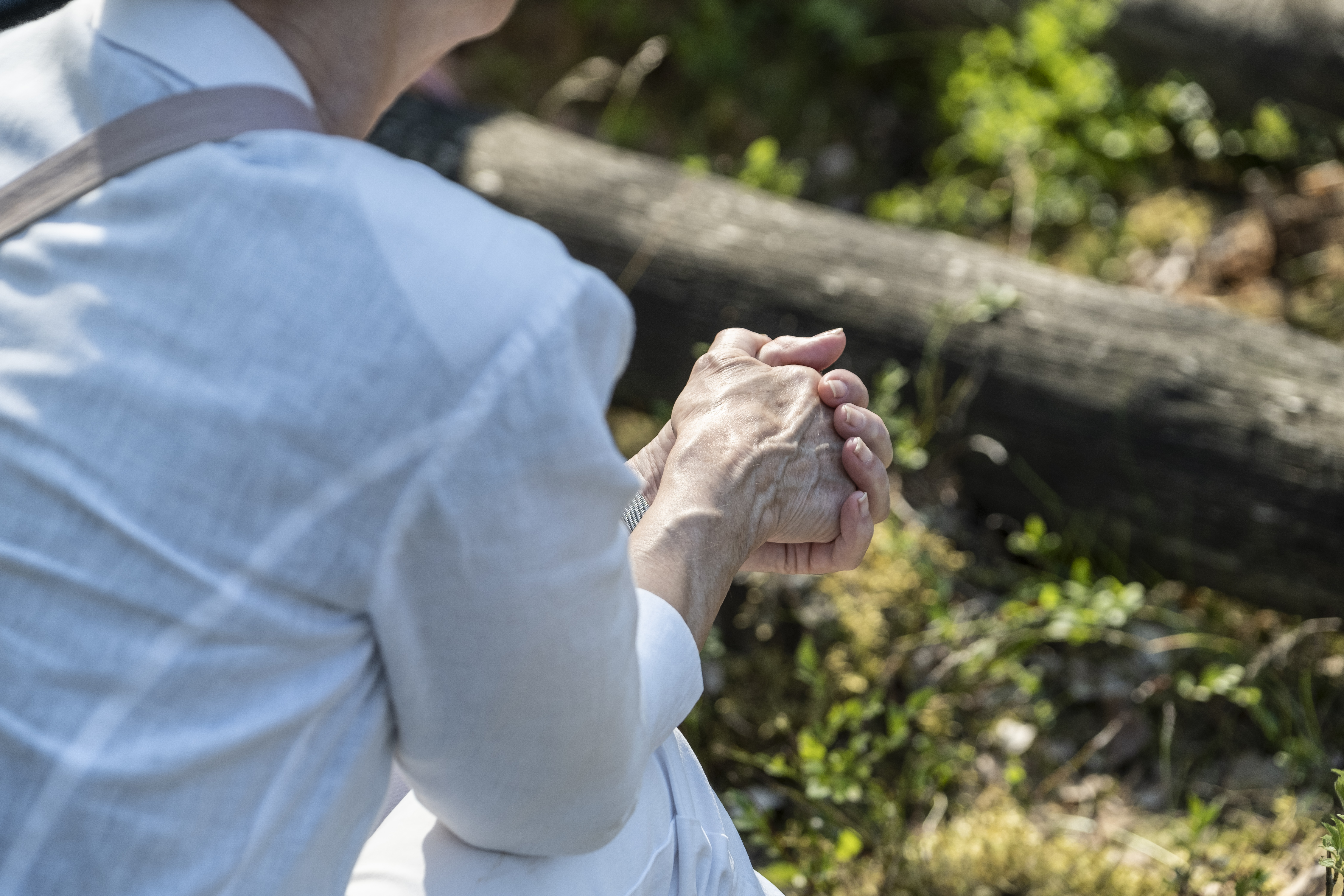 En person i skjorta sitter i skogen.