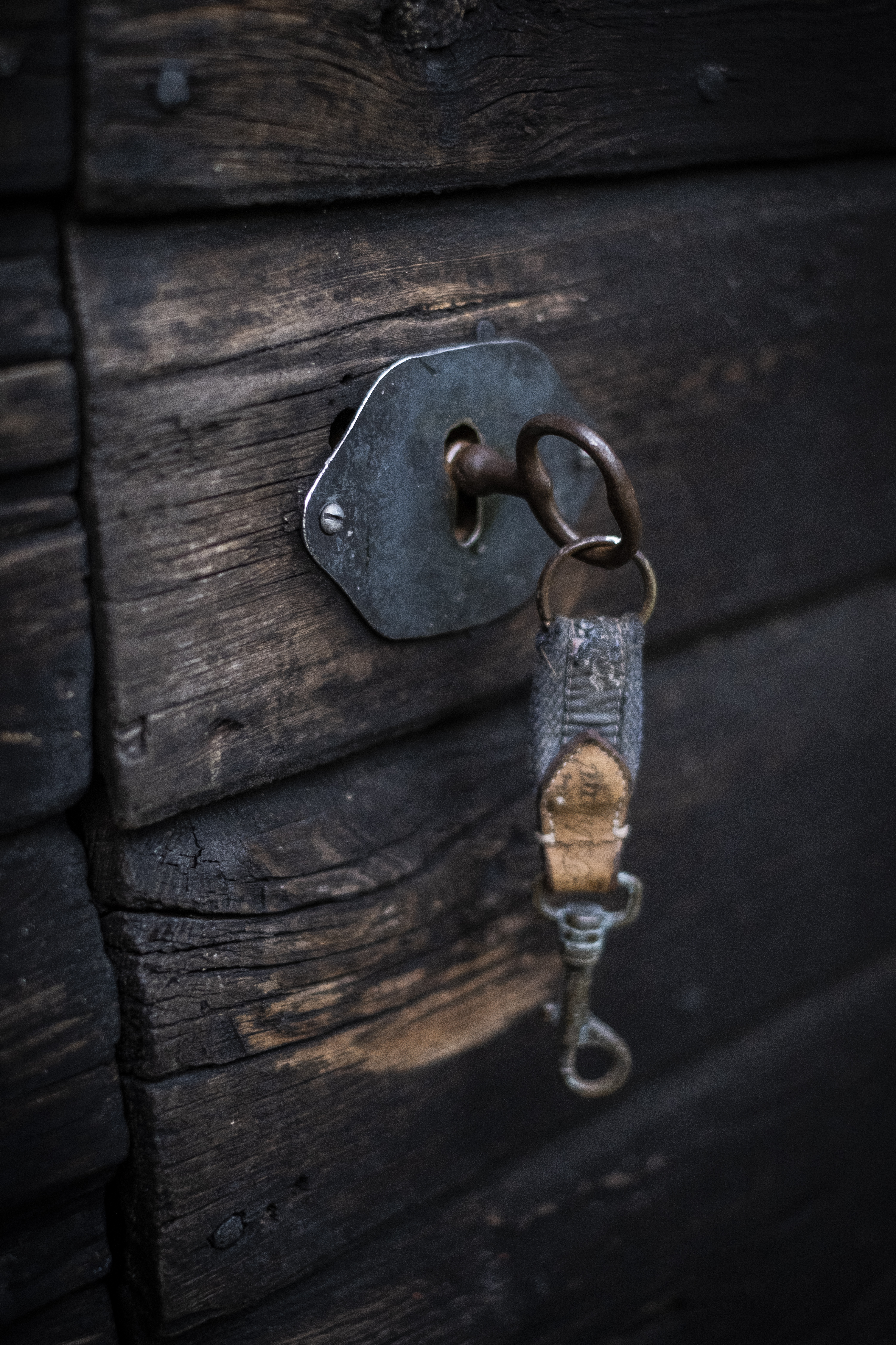 En nyckel sitter i låset på en gammal träddörr.