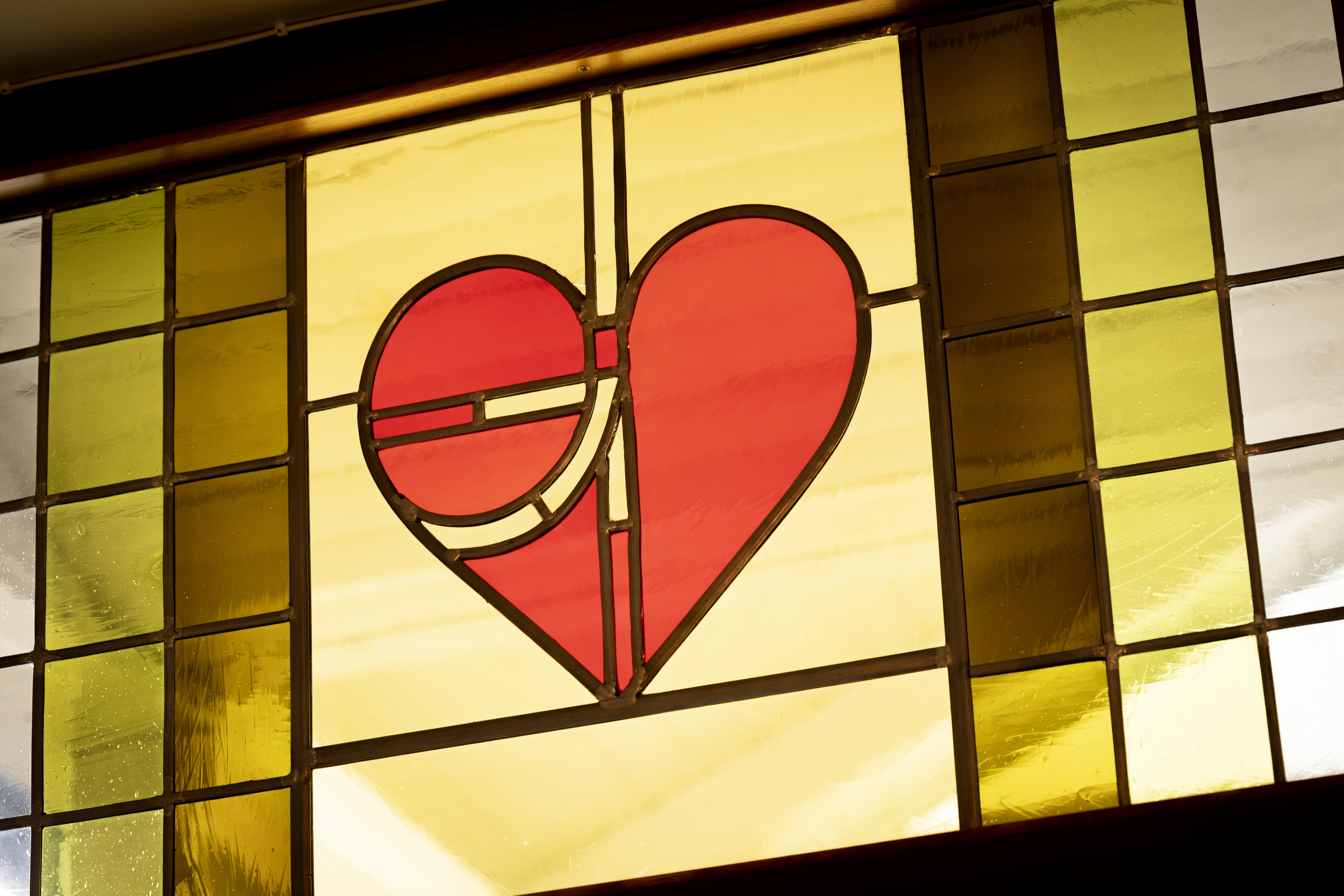 Ett blyinfattat färgat glasfönster med ett rött hjärta.
