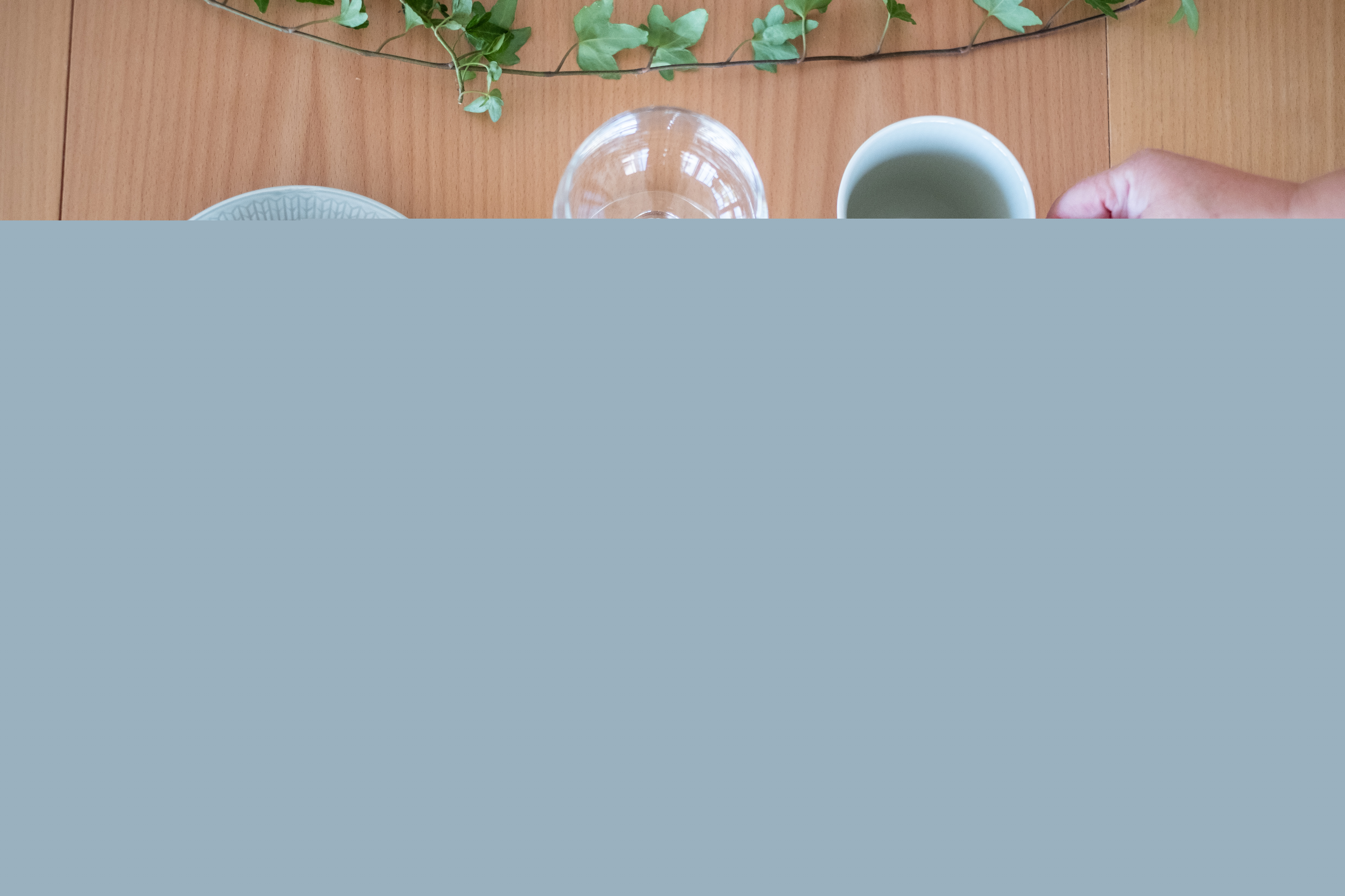 En skål soppa och en brödbit står framdukat på ett bord.