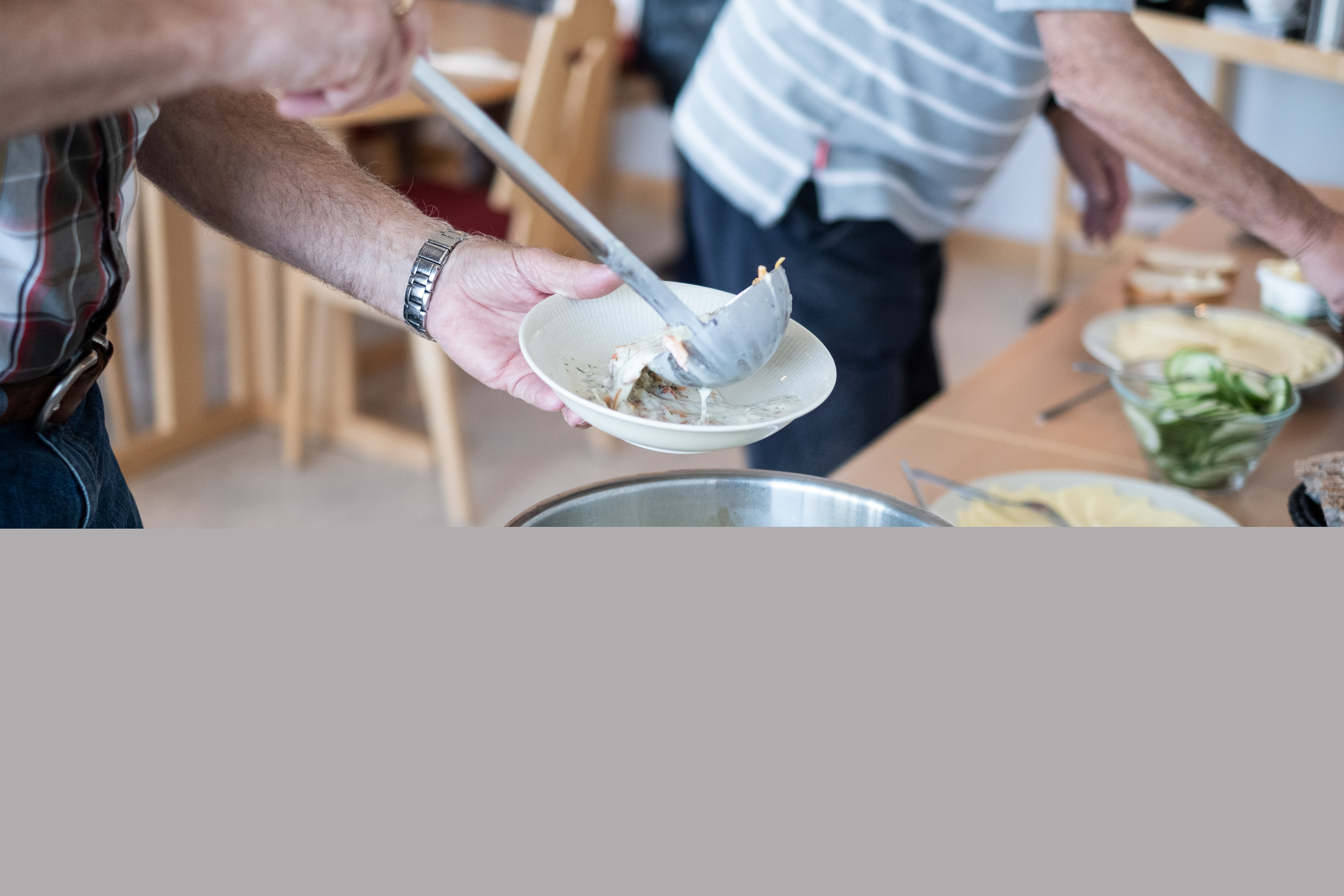 Någon tar en slev soppa ur en kastrull.