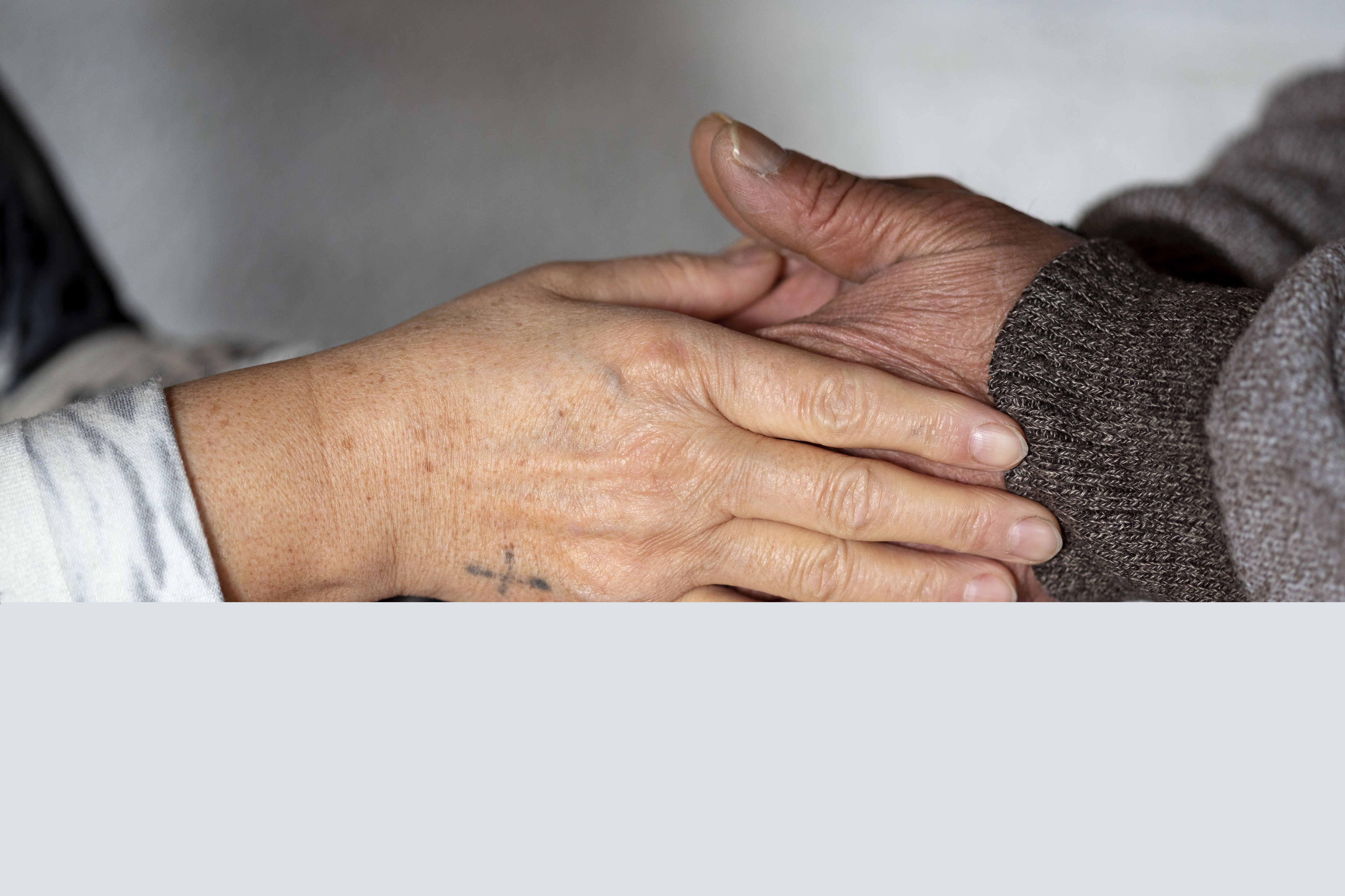 Två personer håller om varandras händer.