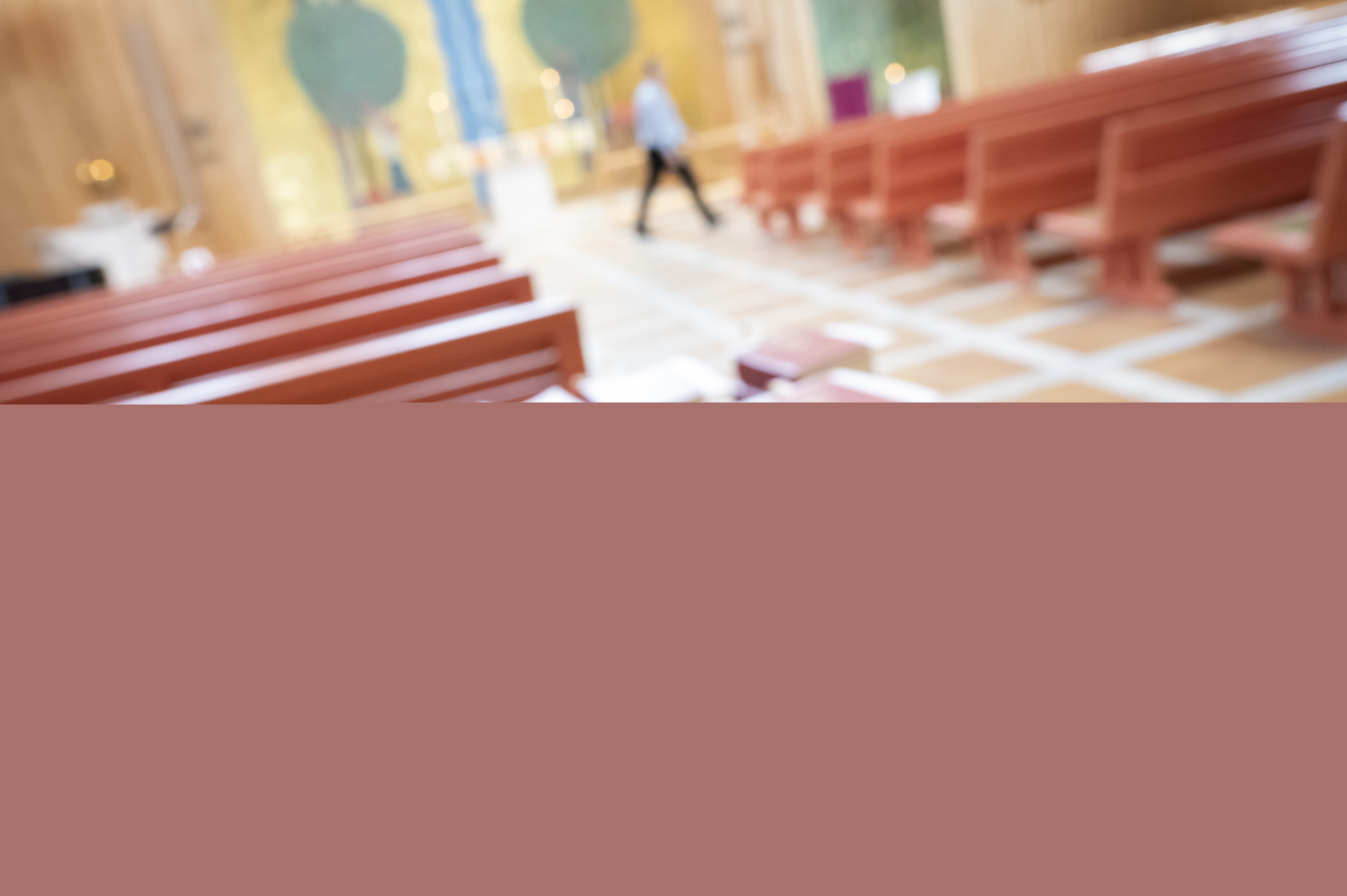 En person i en kyrka håller i en manuell räknare för räkna antalet besökare.