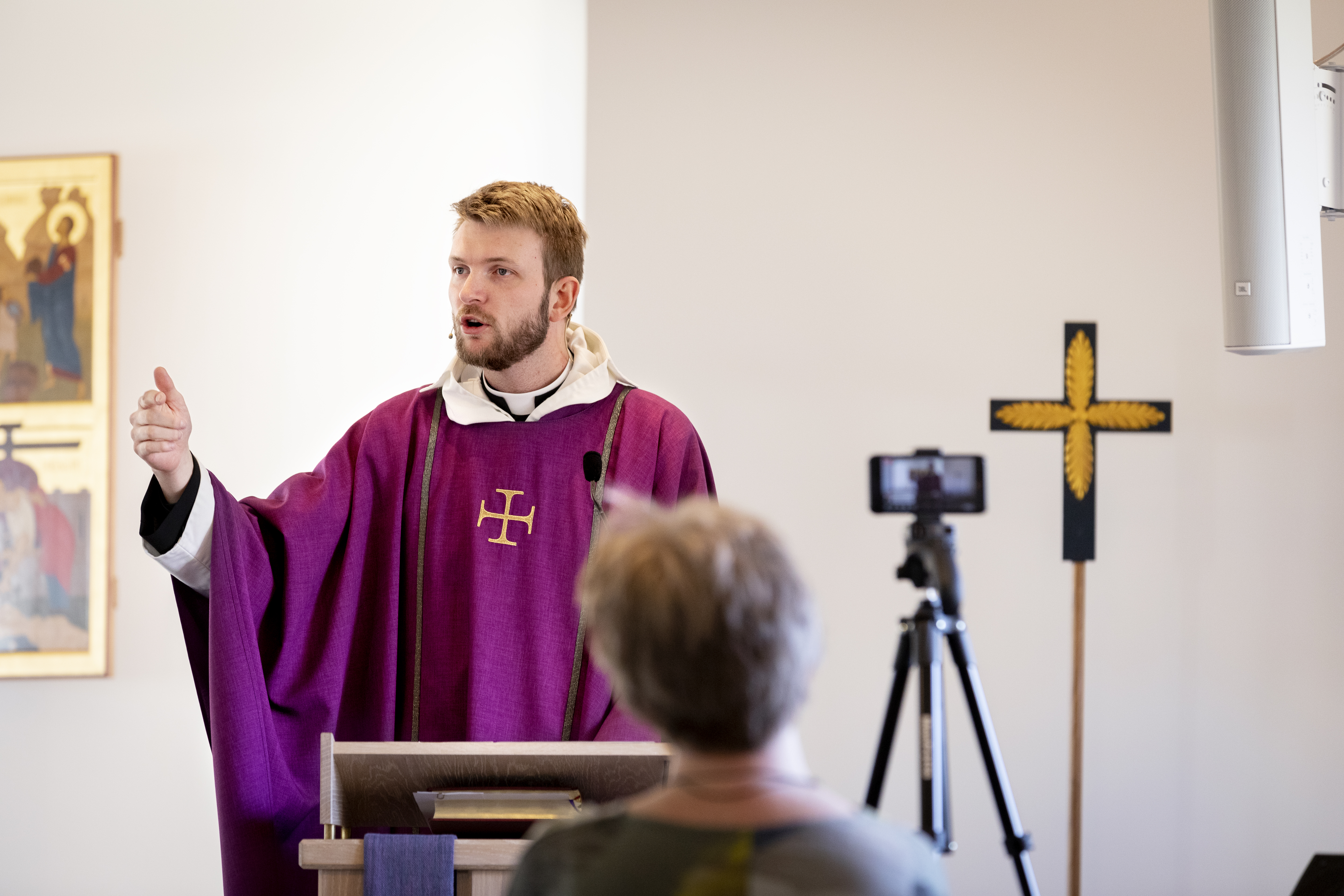 En präst predikar framför en kamera som filmar för direktsändning på webben.