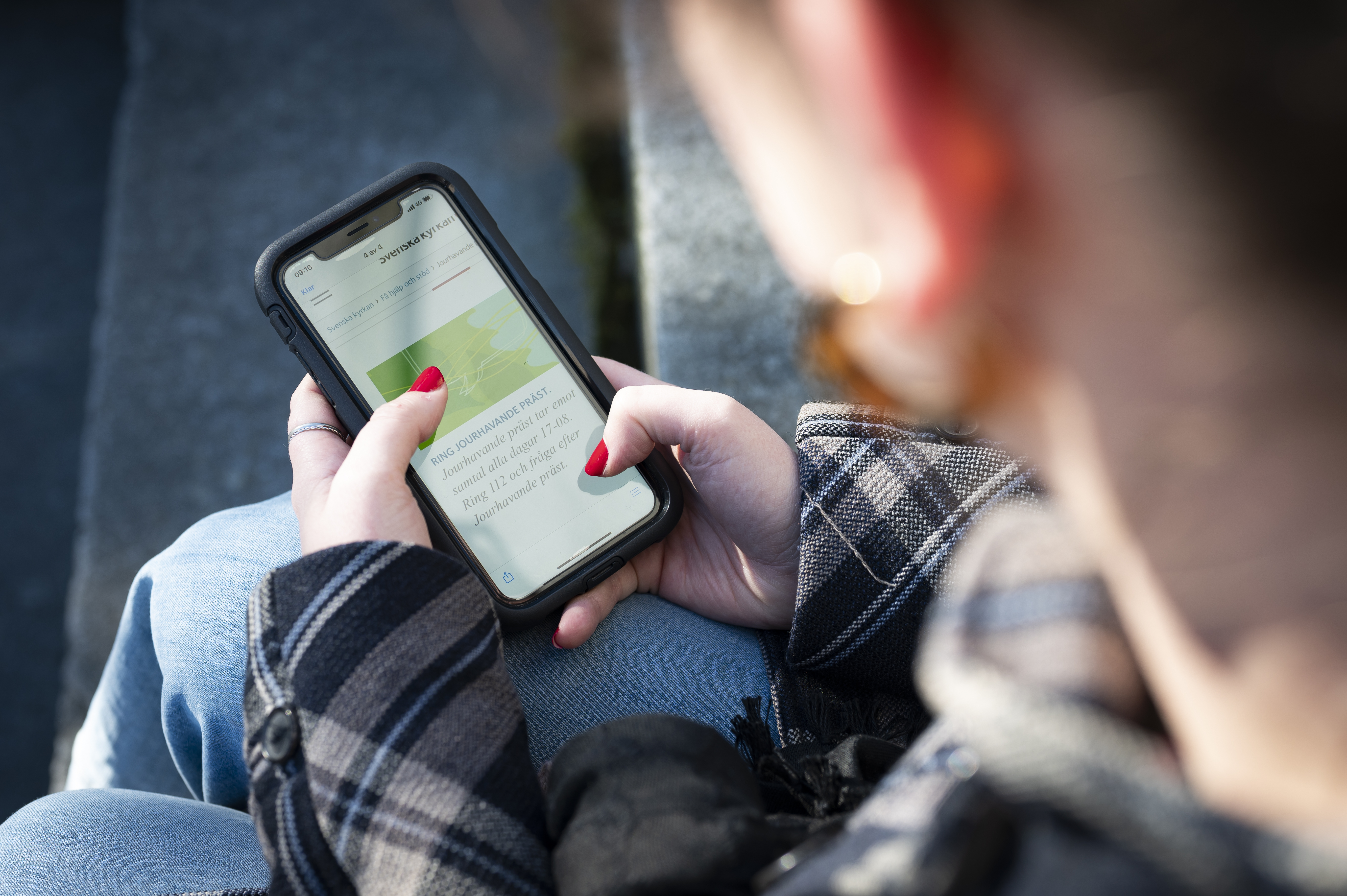 En person sitter och surfar på sin mobiltelefon.