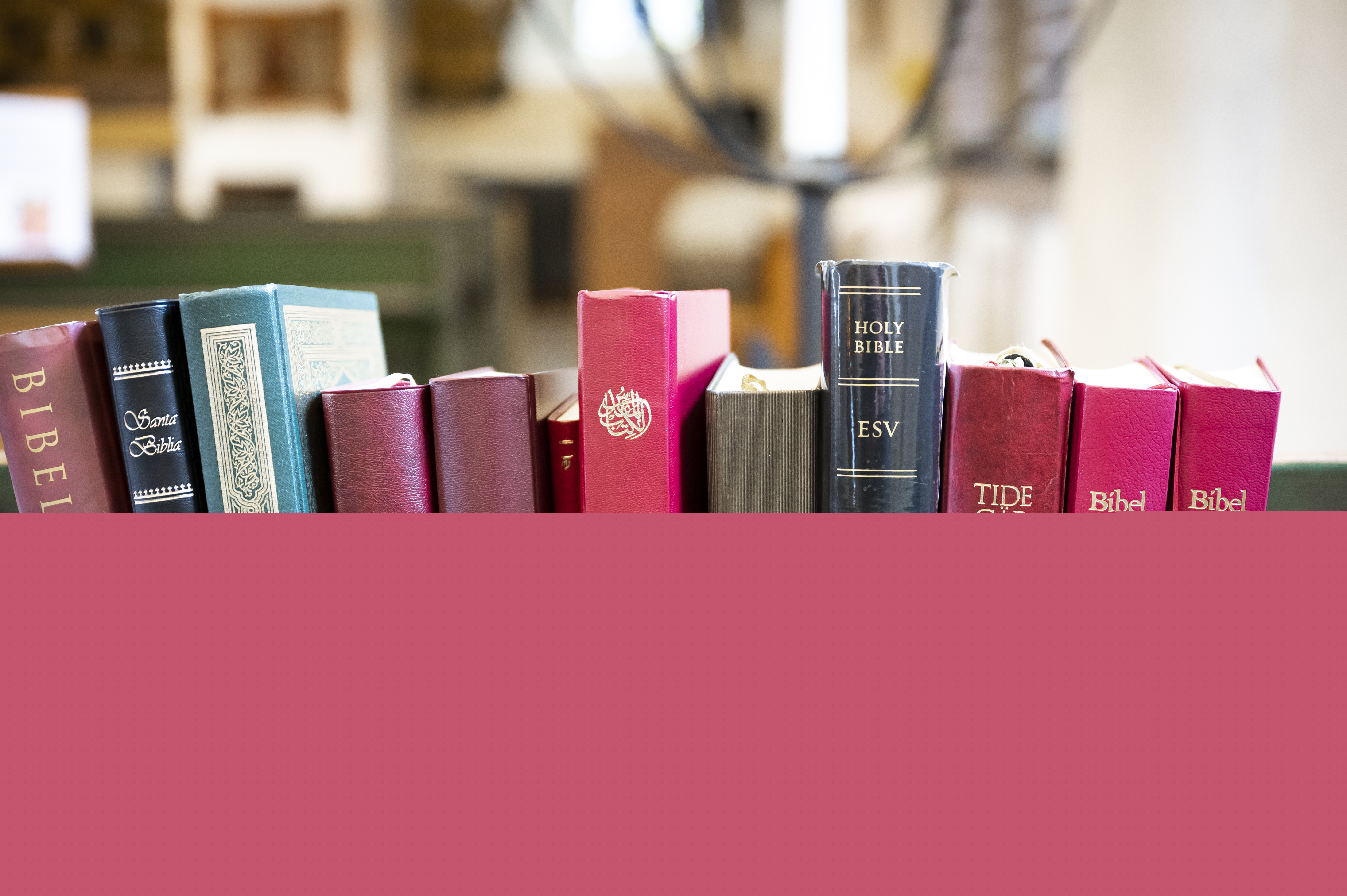 Biblar på olika språk står i en bokhylla i kyrkan.