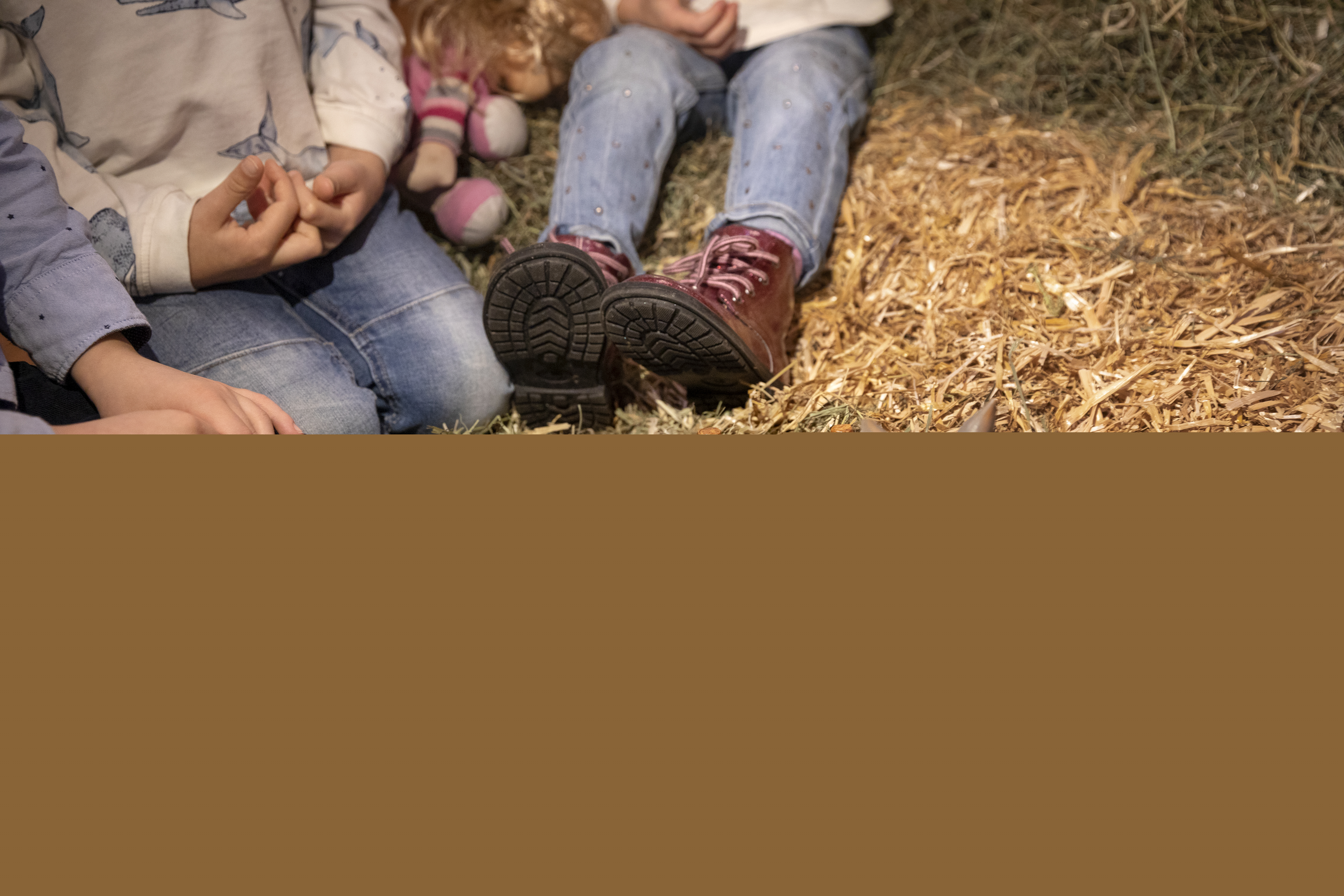 Några barn leker med dockorna i julkrubban.