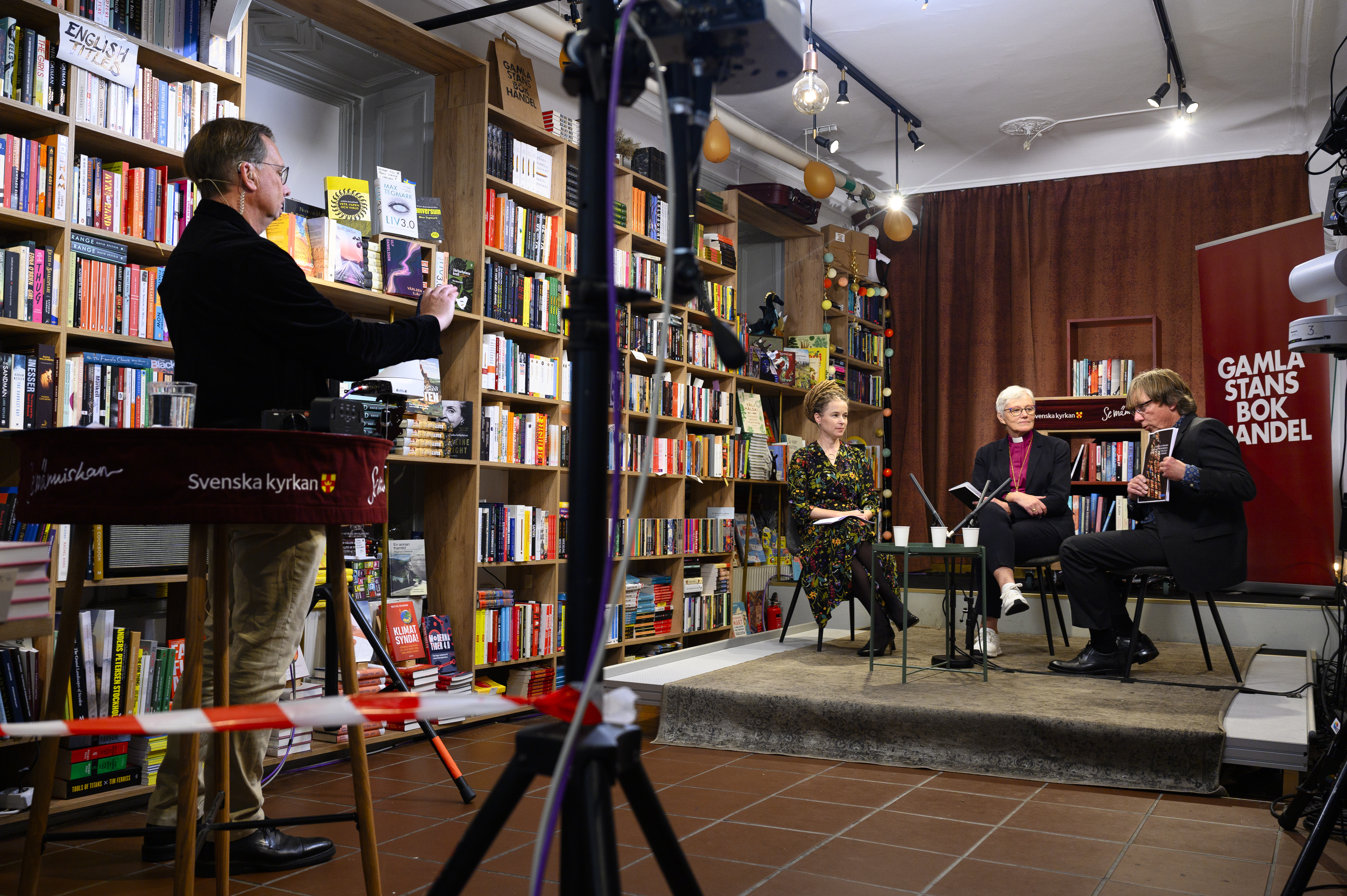 En TV-studio har byggts upp i en bokhandel. Vid ett bord sitter Kulturminister Amanda Lind och ärkebiskop Antje Jackelén.