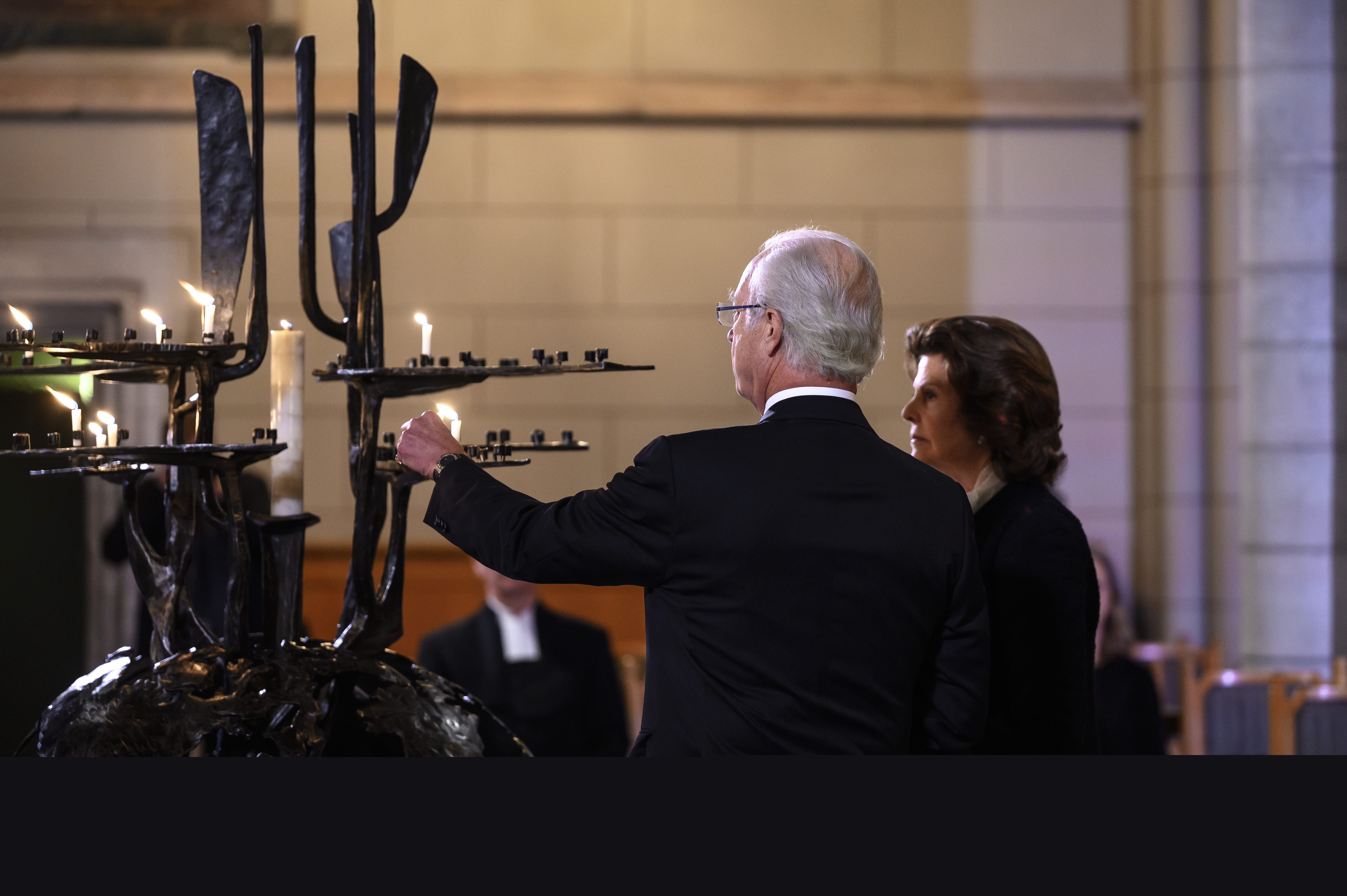 Kung Carl XVI Gustav och drottning Silvia tänder ljus i Uppsala domkyrka.