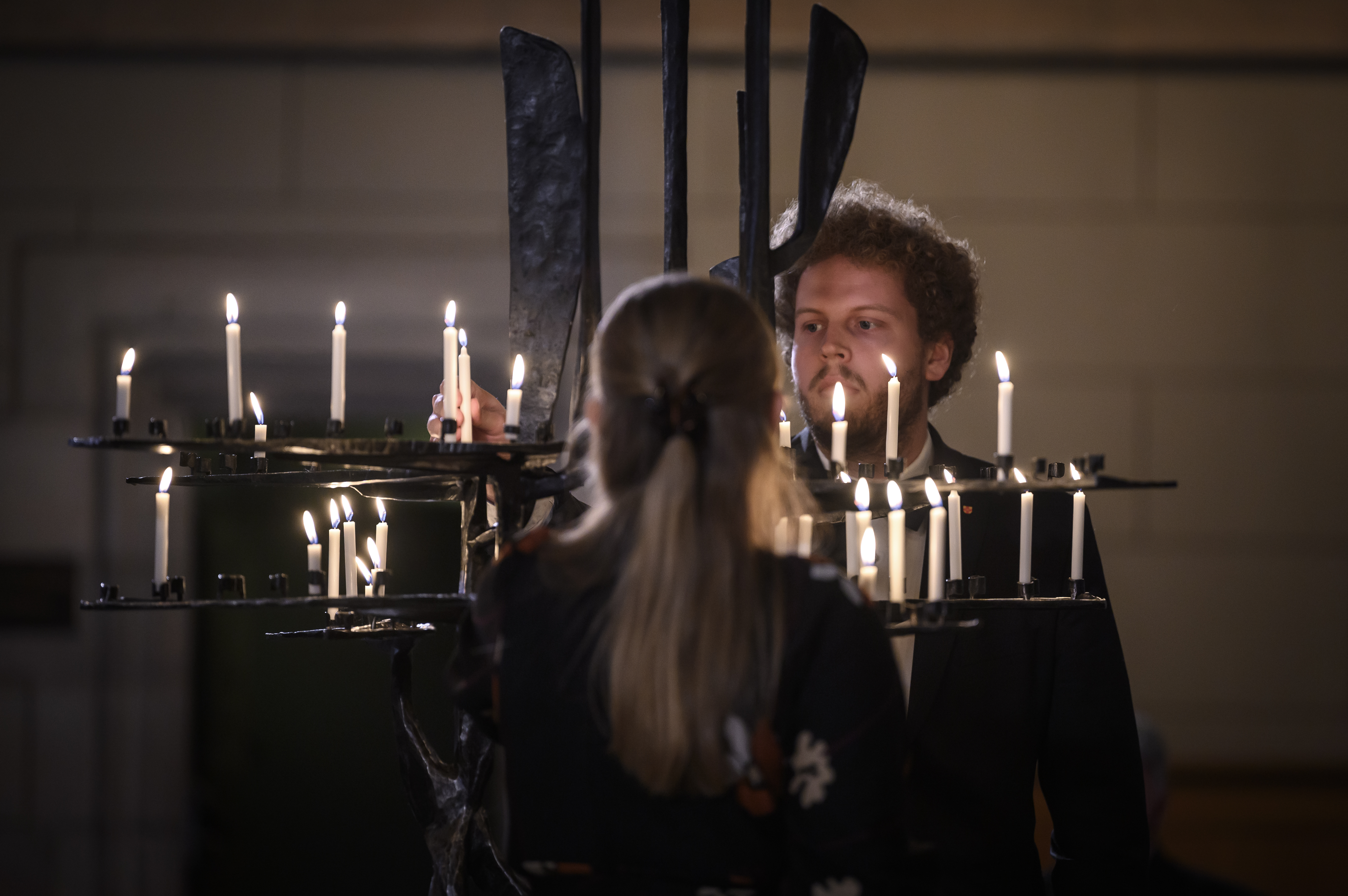 Två personer tänder ljus i Uppsala domkyrka.