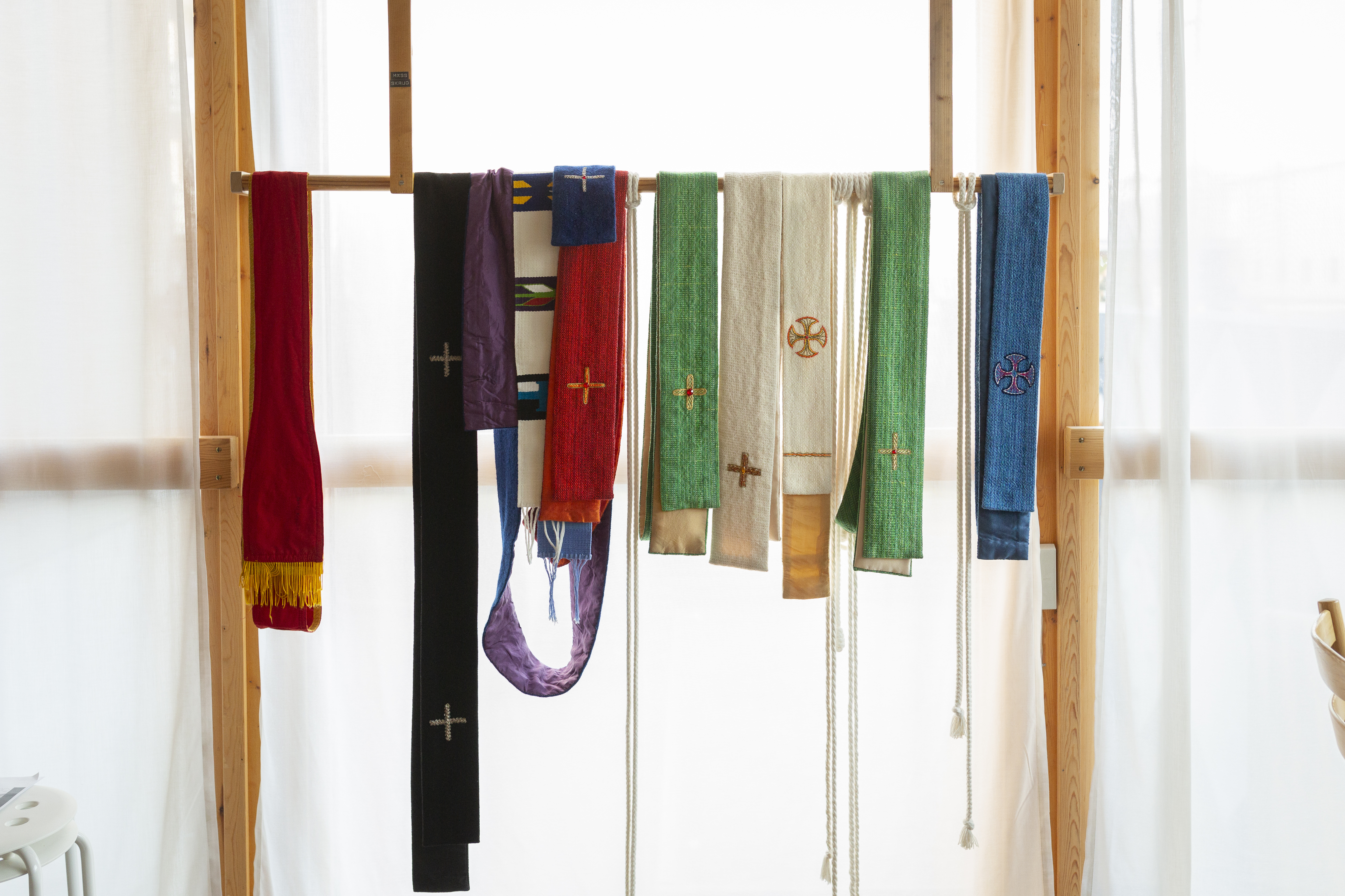 Stolor i olika färger hänger på en ställning.