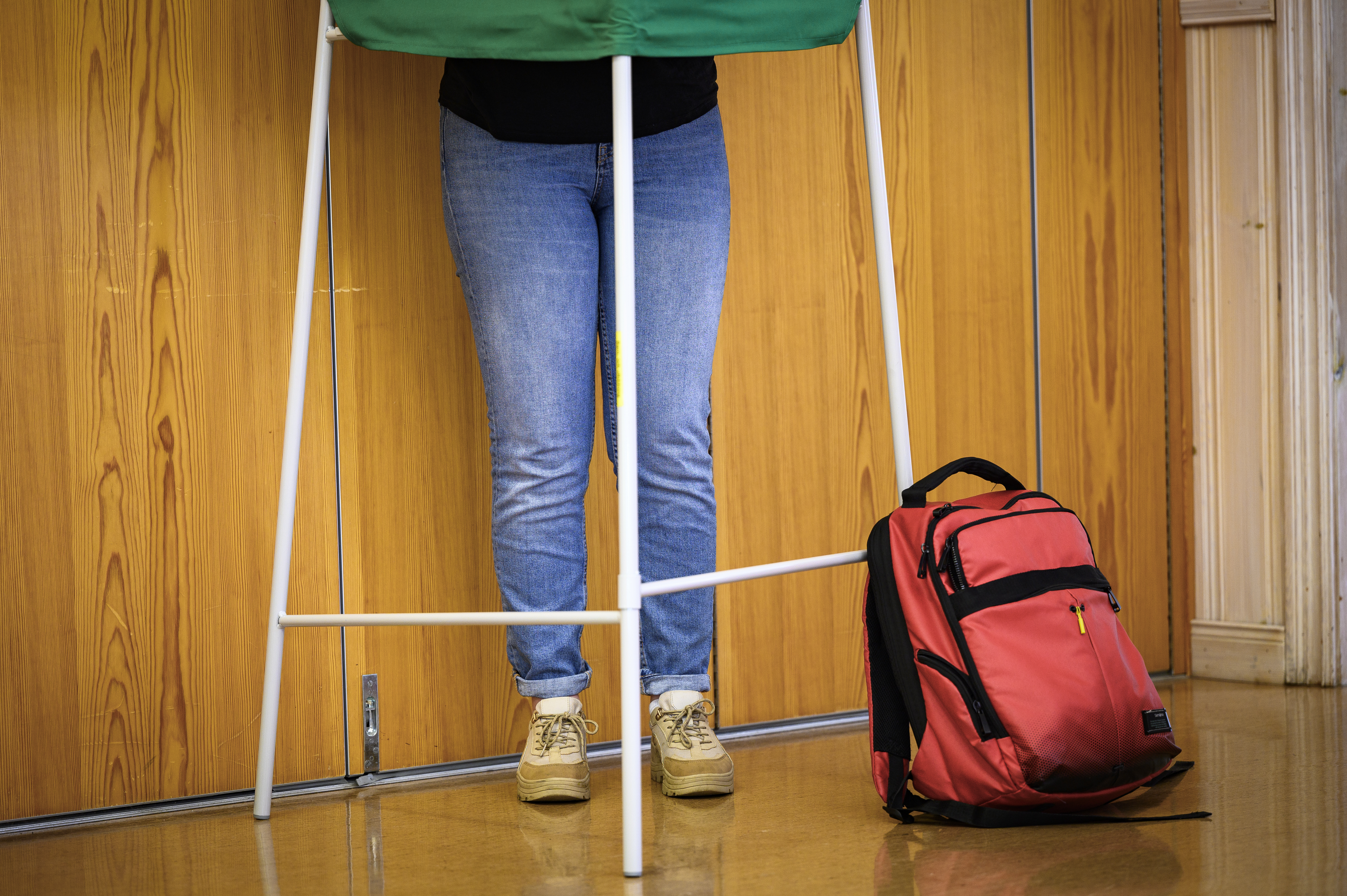 Benen på någon som står i ett valbås.