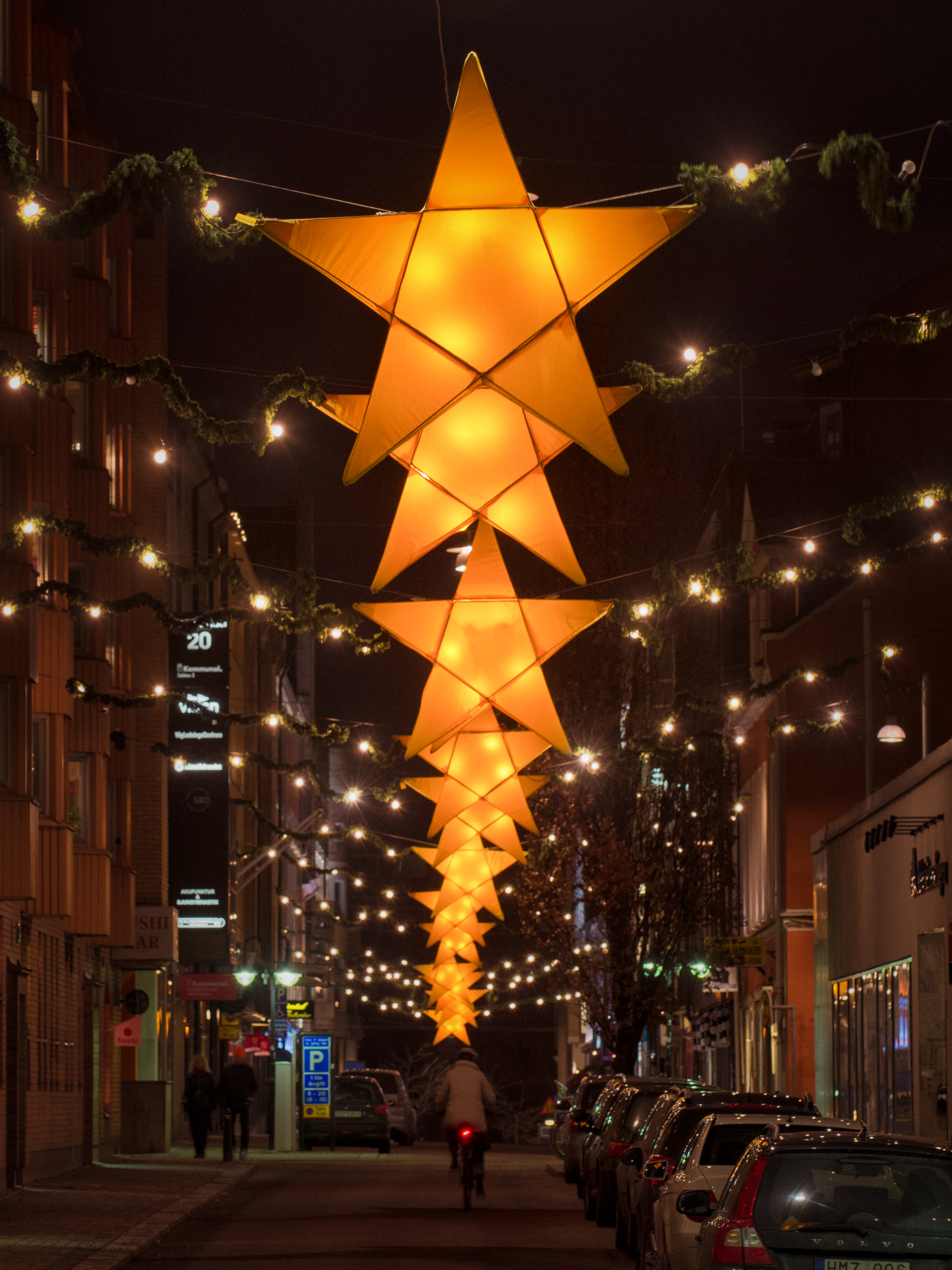 En lång rad med adventsbelysning hänger över en gata.