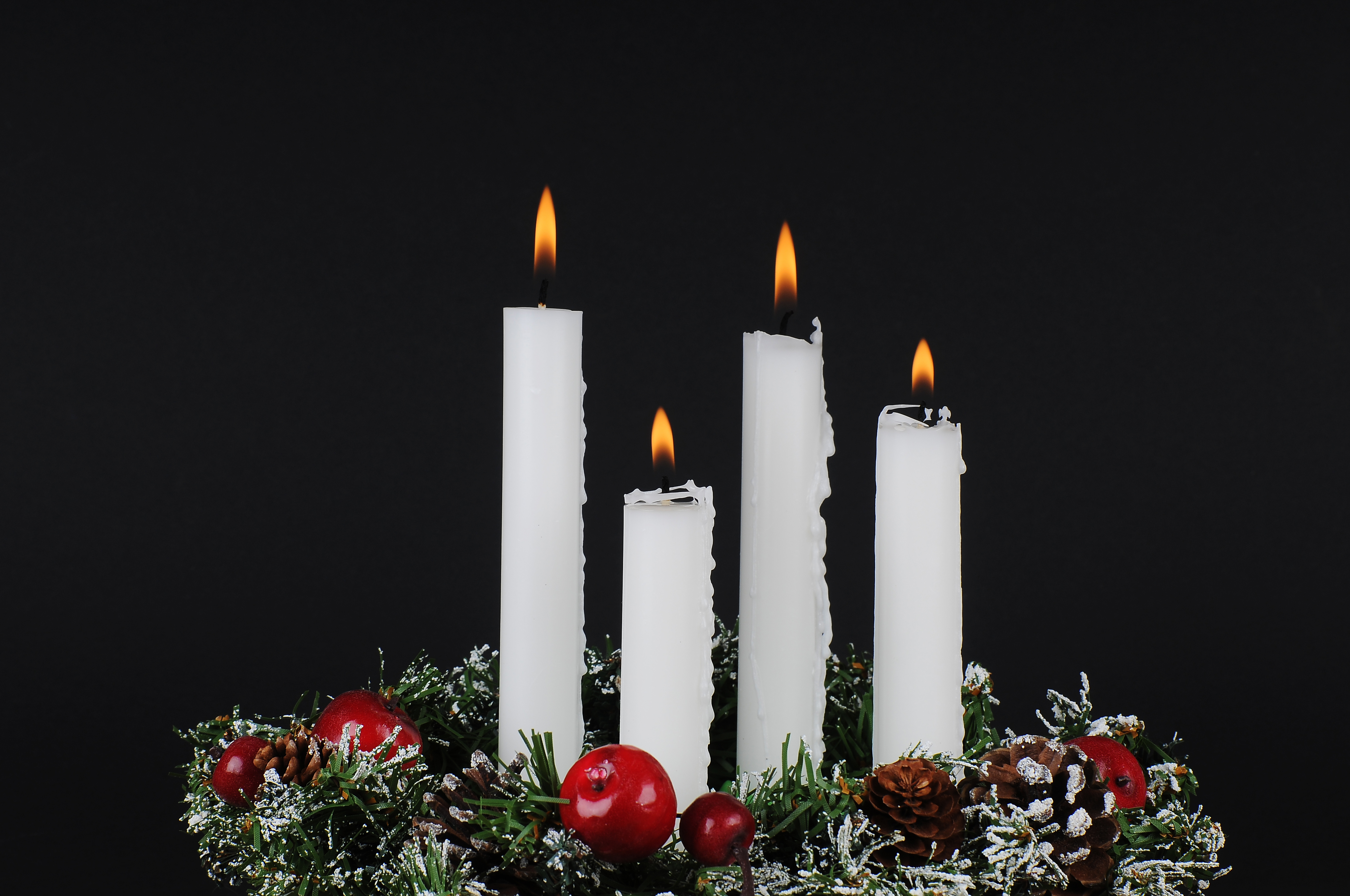Fyra ljus brinner i en adventsljusstake.
