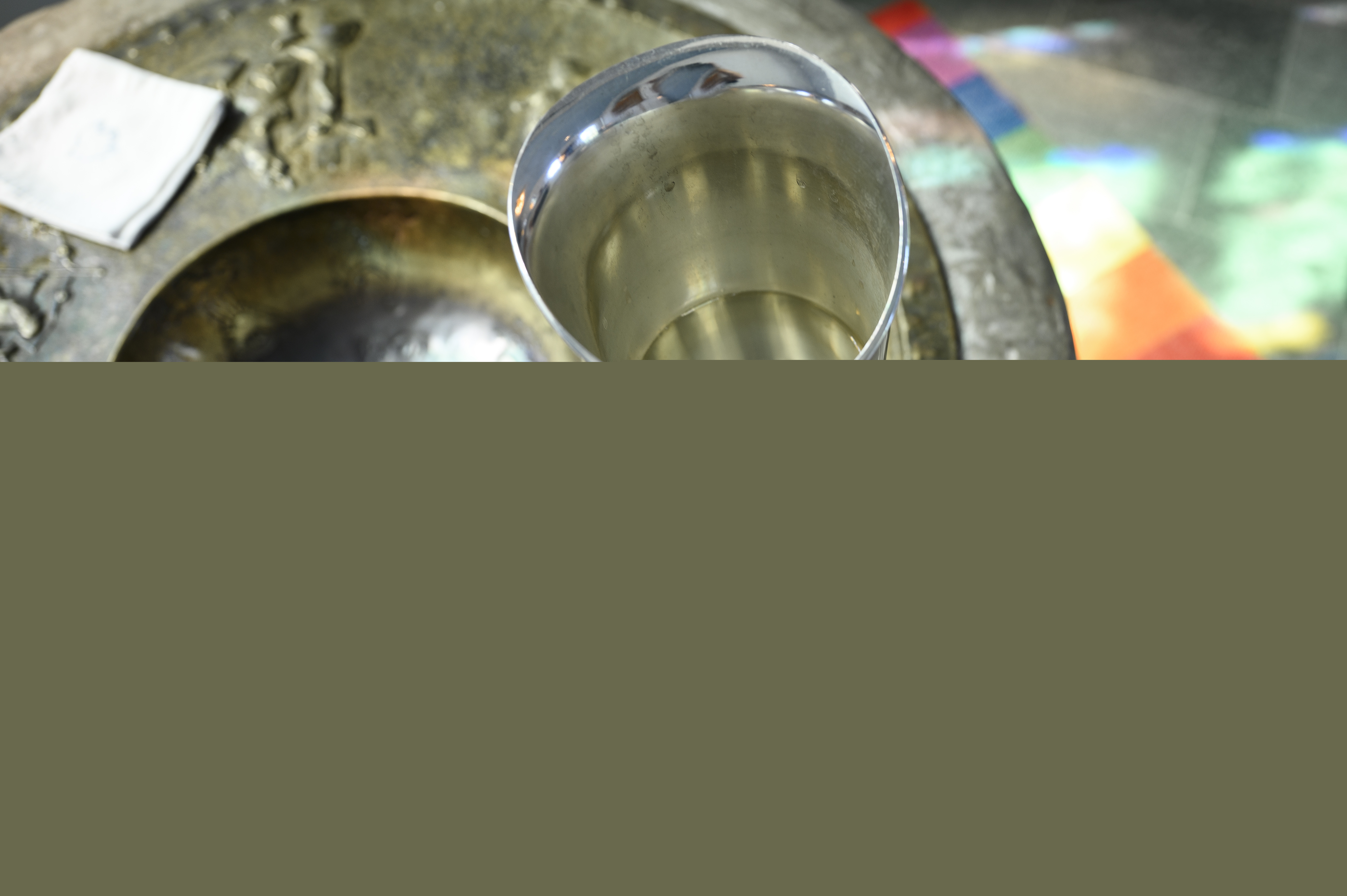 En kanna vatten står på en dopfunt.