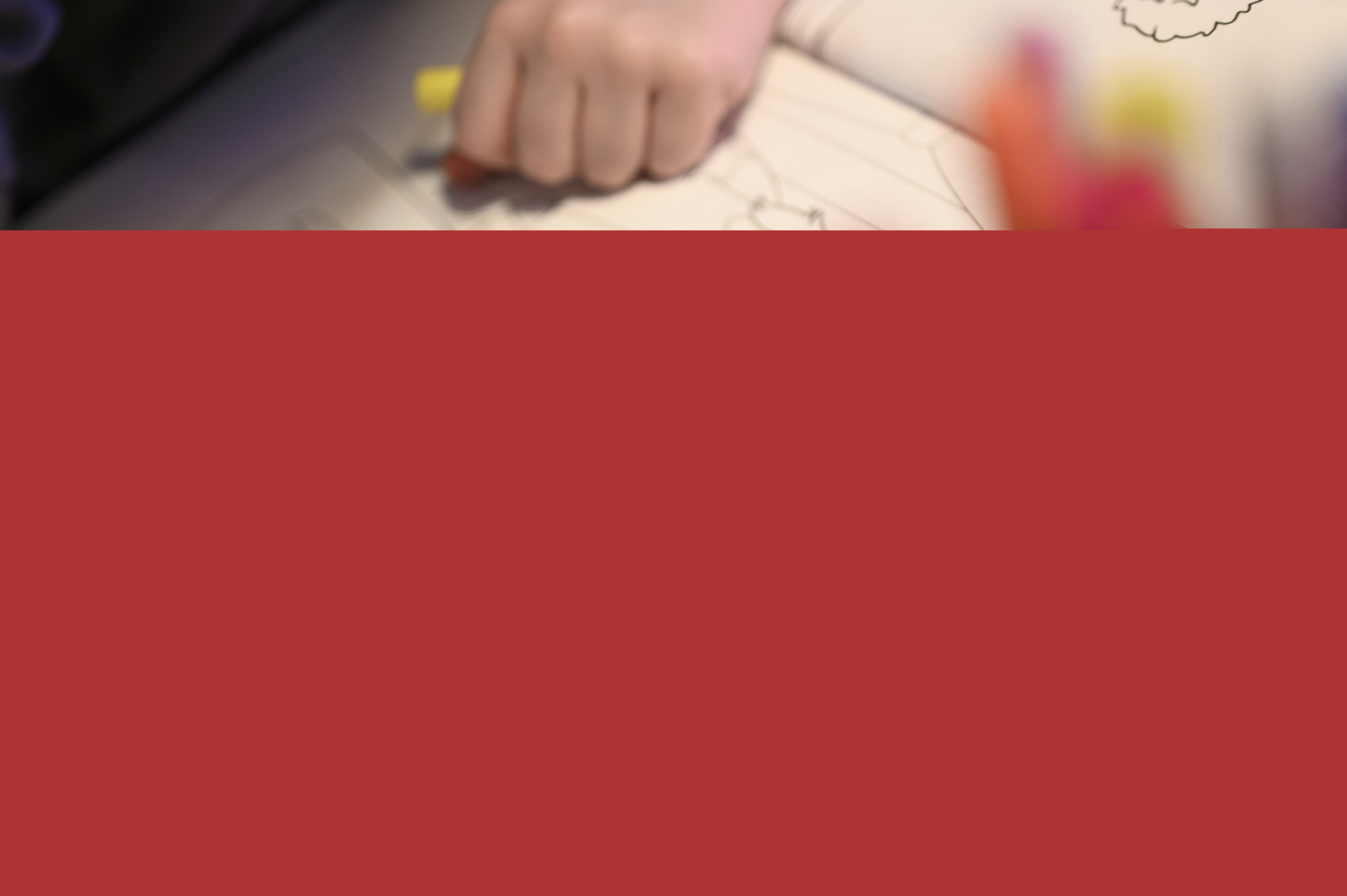 Närbild på ett barn som sitter och färglägger i en målarbok med jultema.