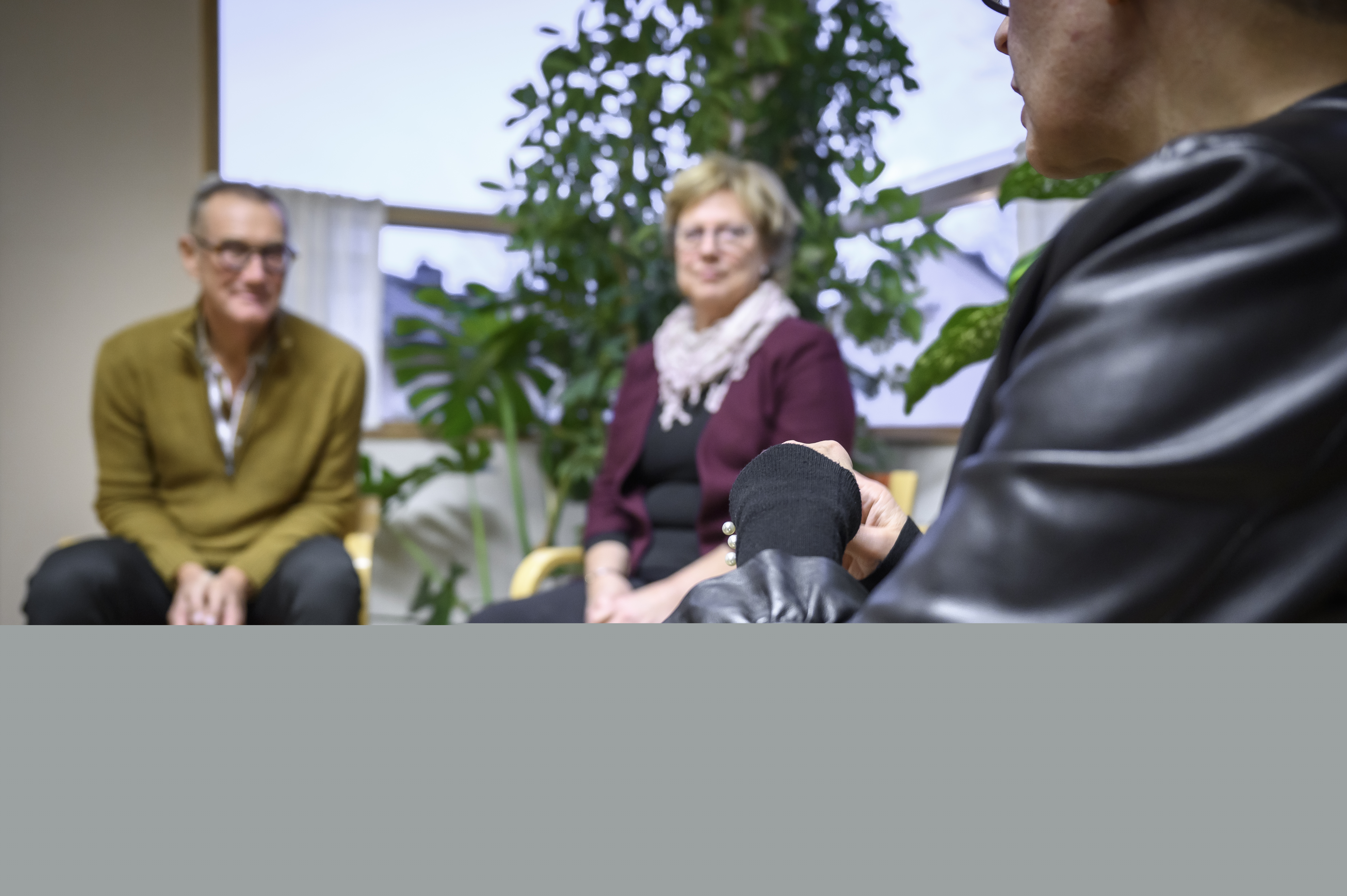 Några personer sitter och samtalar inomhus.