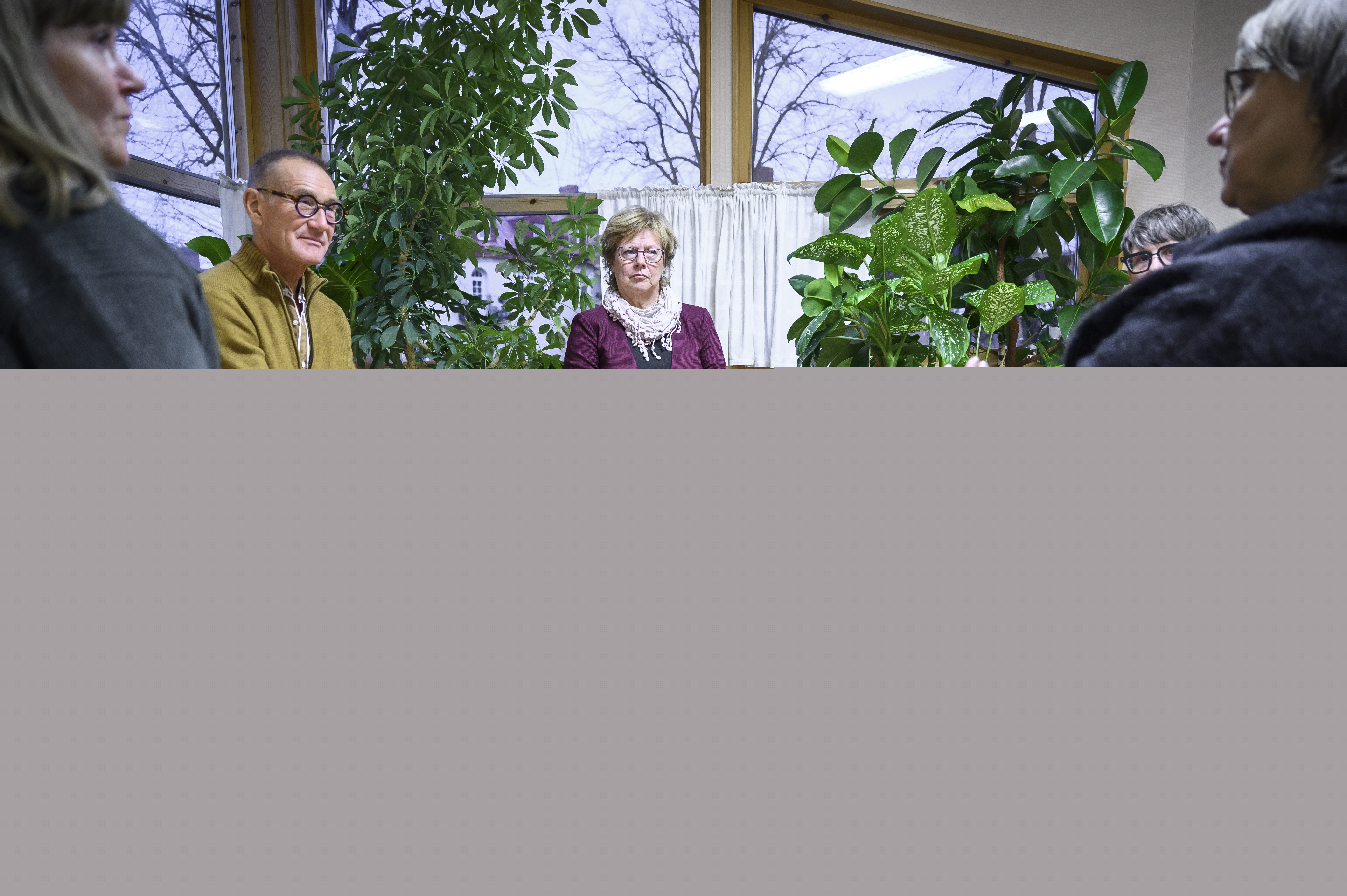 Några personer sitter och samtalar inomhus.