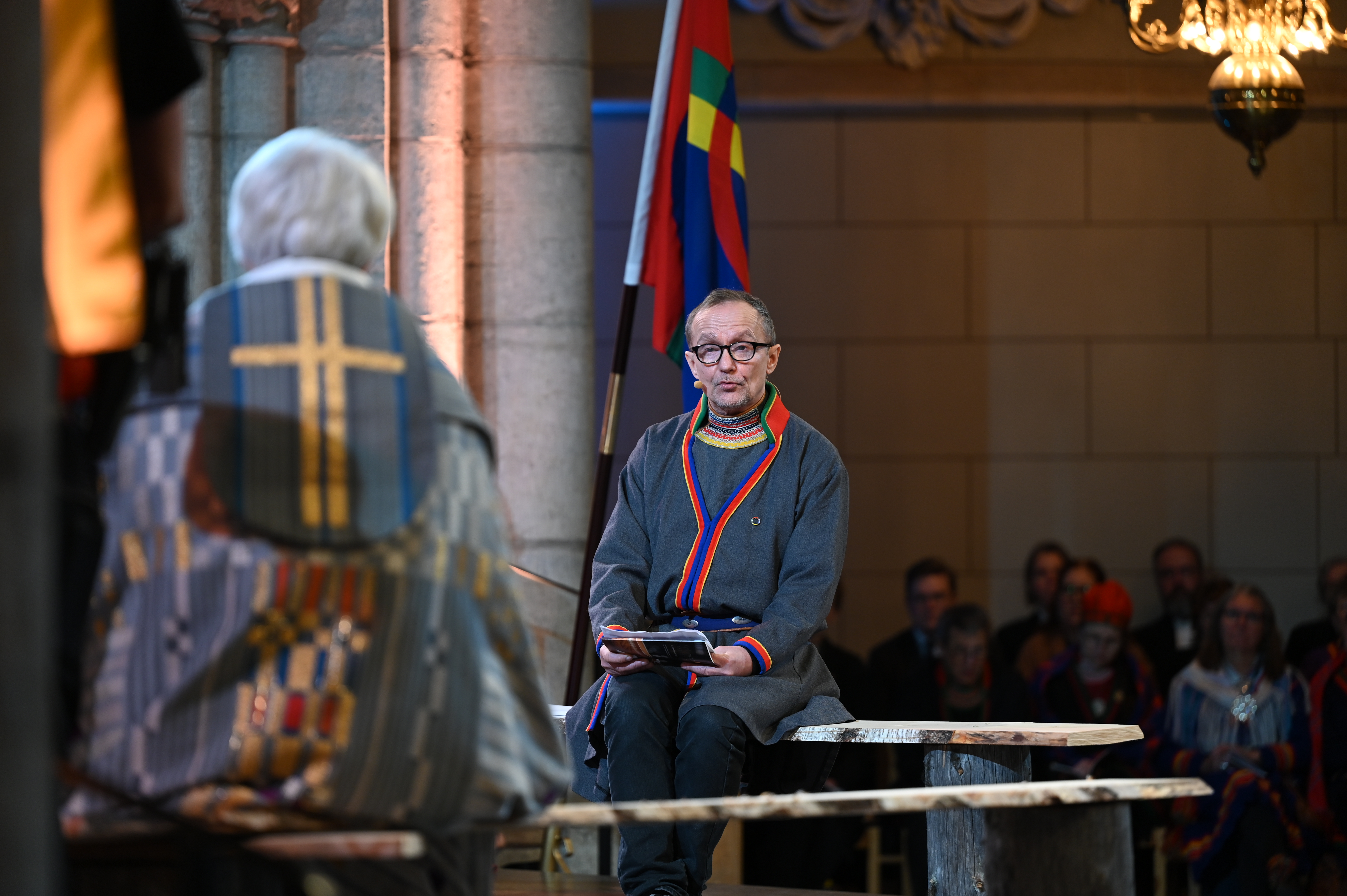 En man i samedräkt sitter mittemot ärkebiskop Antje Jackelén i Uppsala domkyrka.