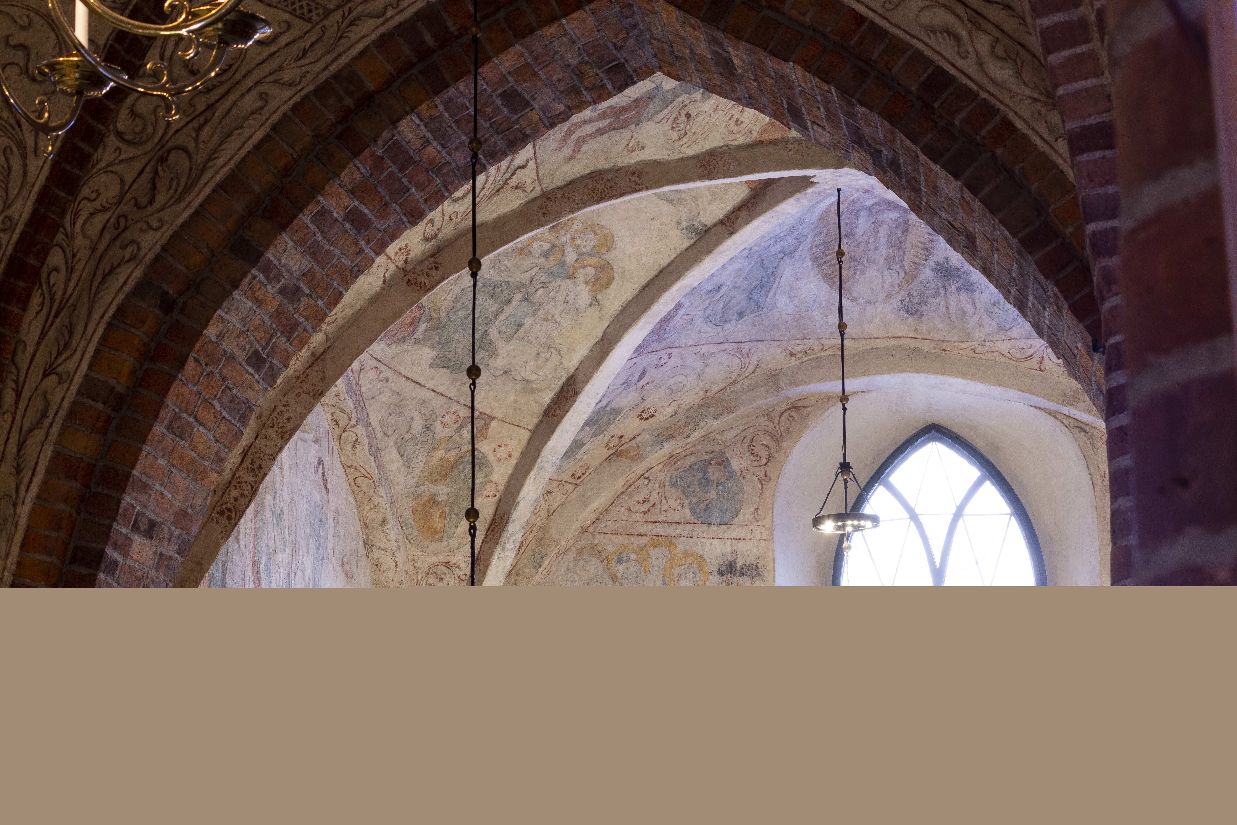 Gamla takmålningar i en tegelkyrka.
