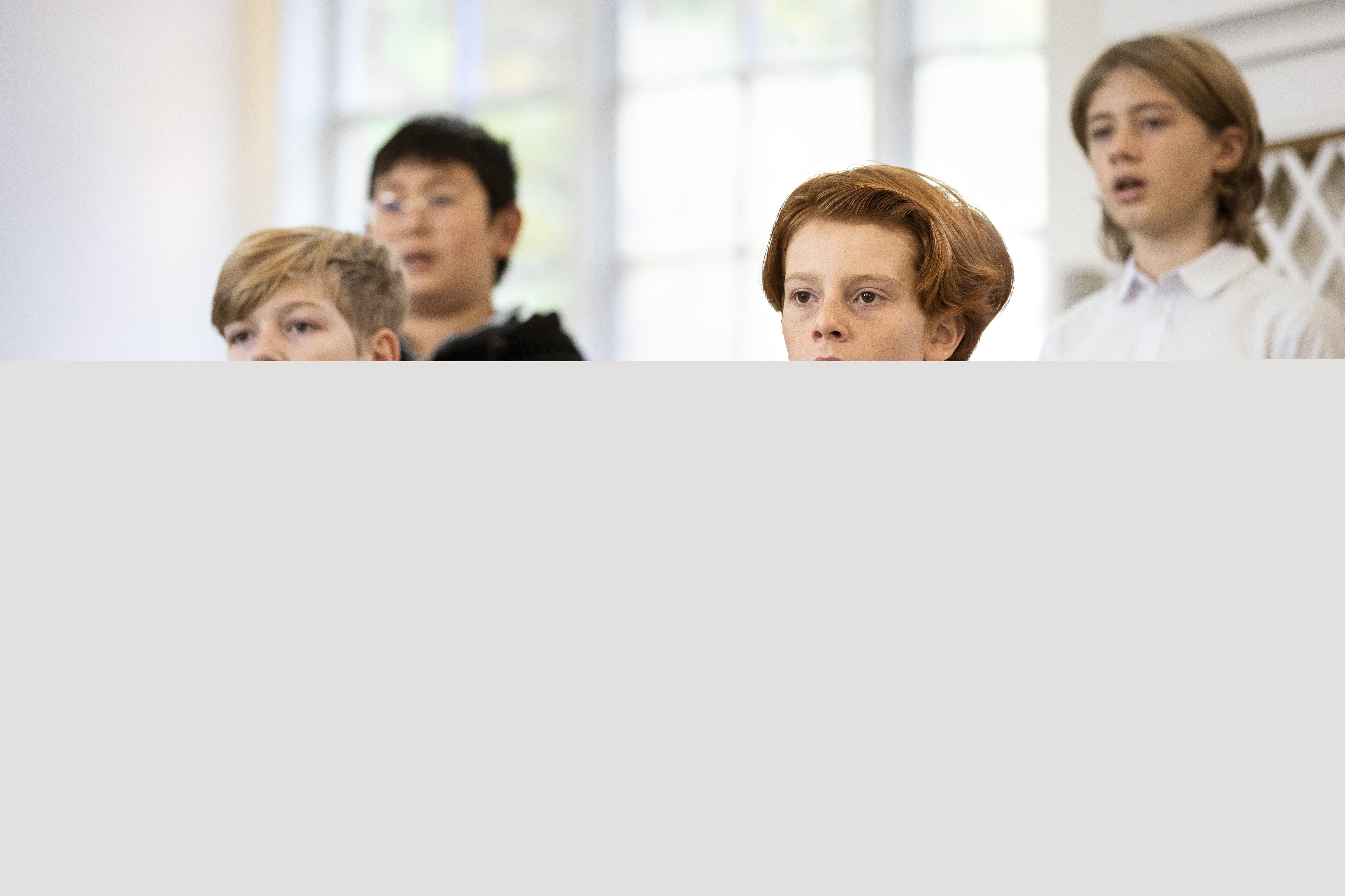 Närbild på medlemmar i en barnkör som sjunger i en kyrka.