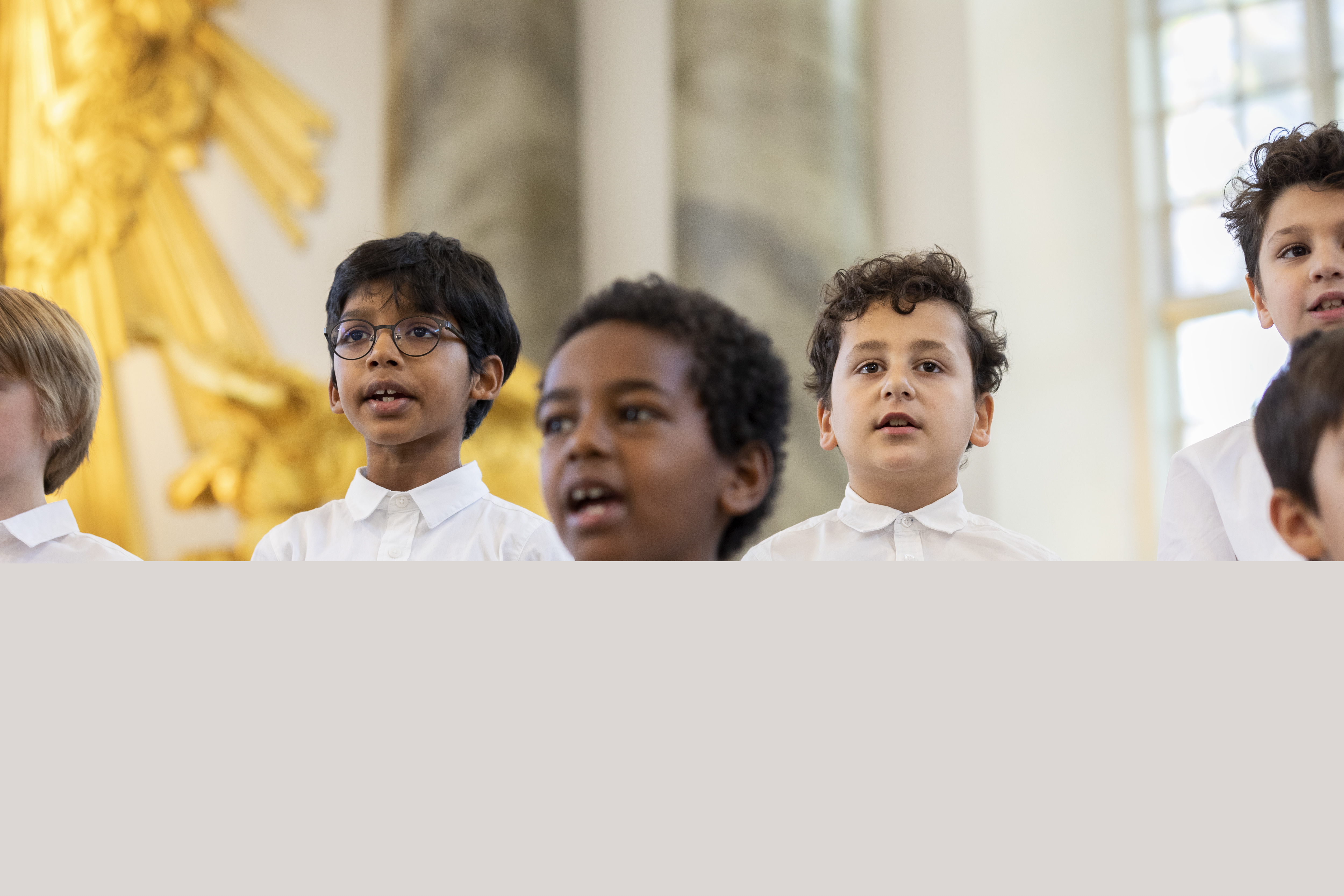 Medlemmar i en barnkör står och sjunger i en kyrka.