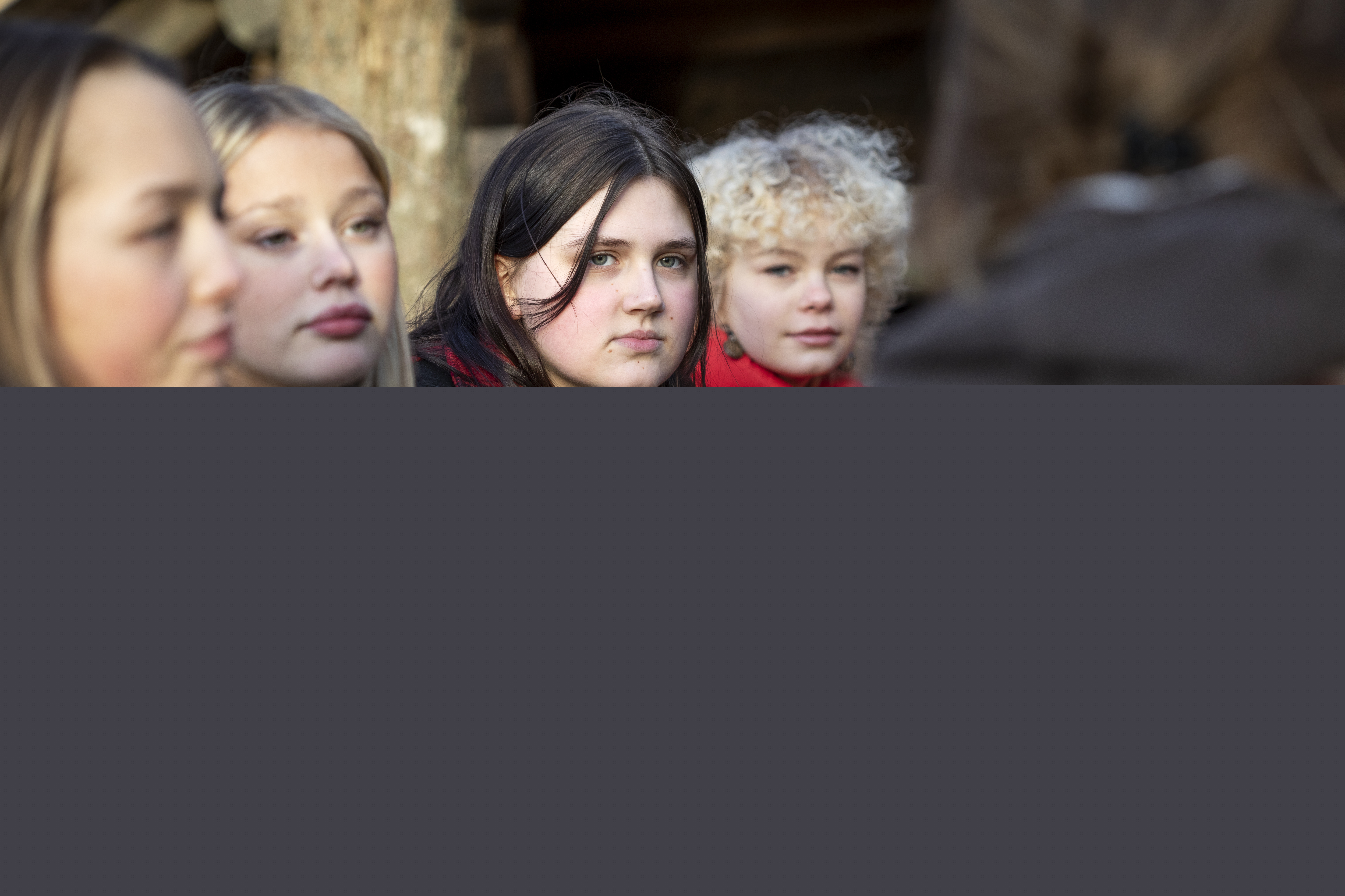 Några tonårstjejer sitter utomhus.