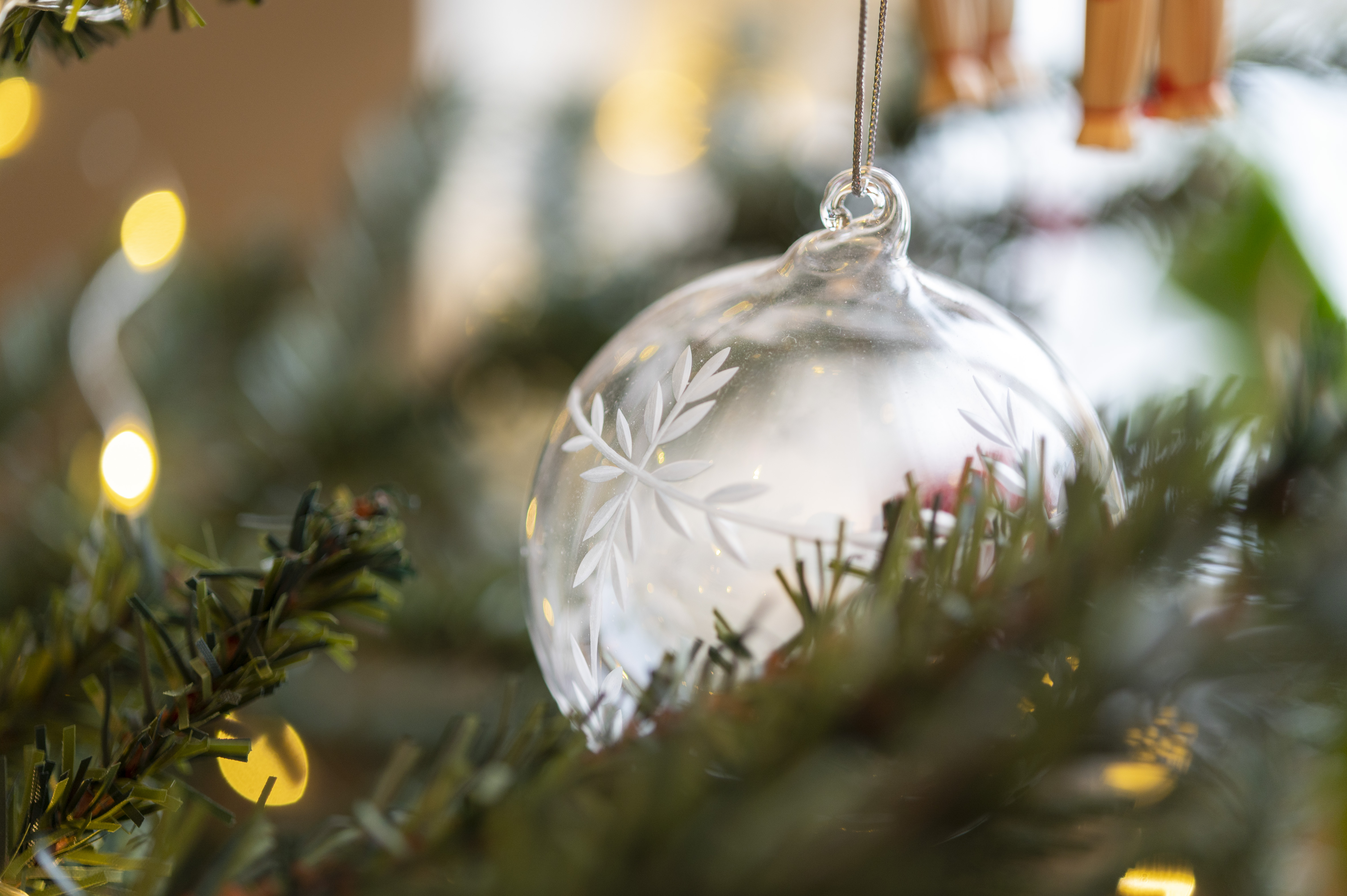 Närbild på en genomskinlig julgranskula i en gran.