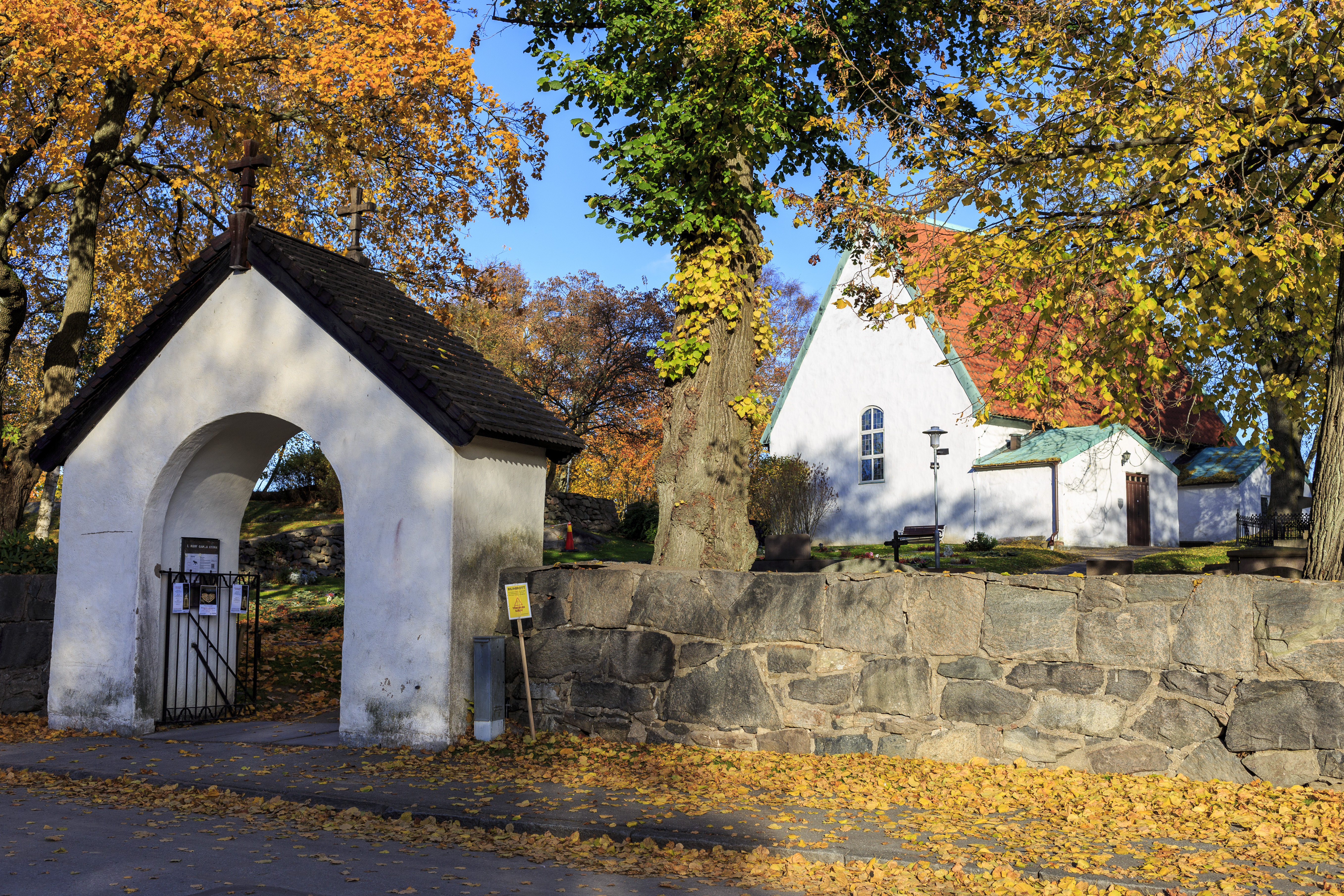 En liten vitputsad kyrka utan torn och med rött tegelttak.
