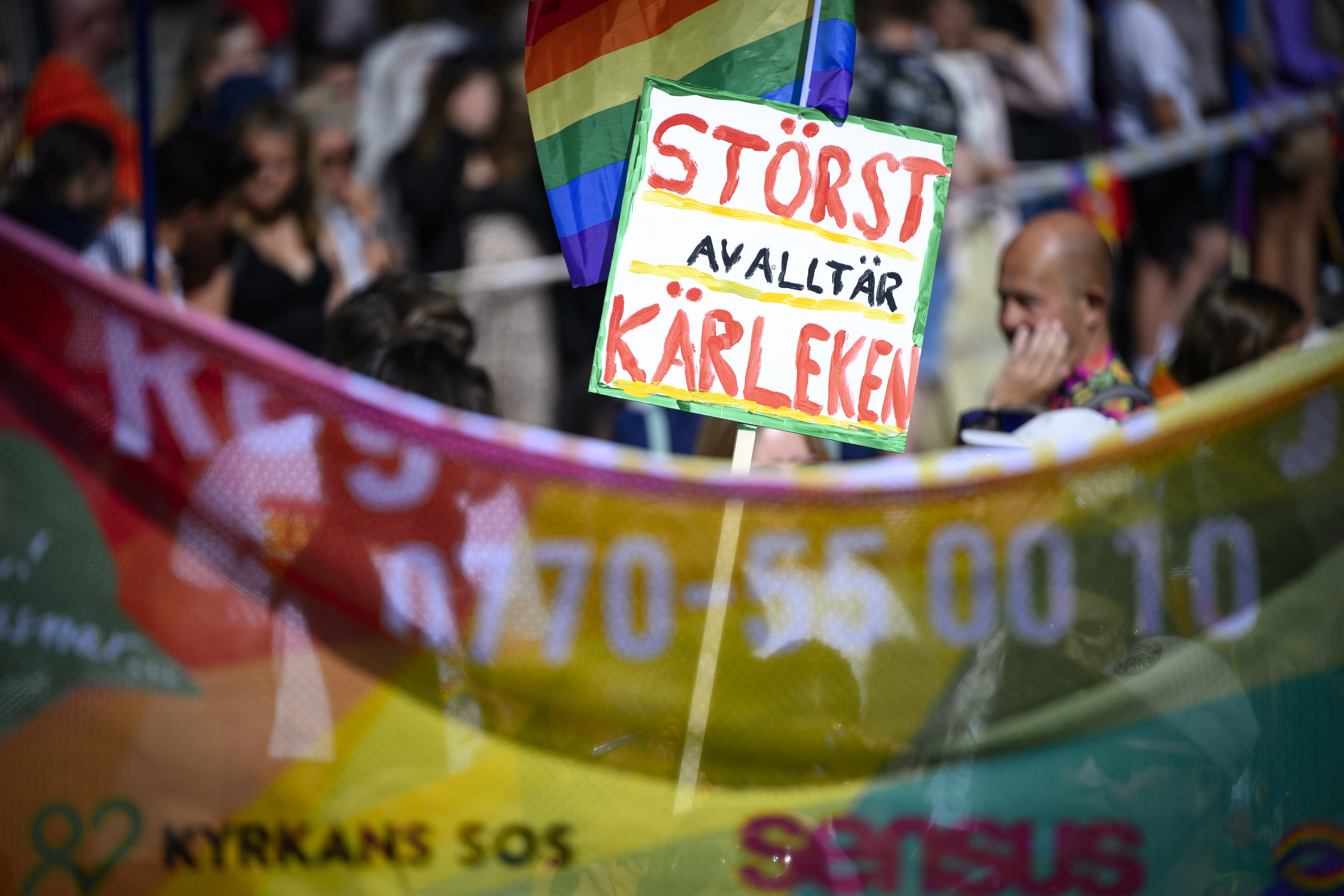 En skylt med texten Störst av allt är kärleken i en prideparad.
