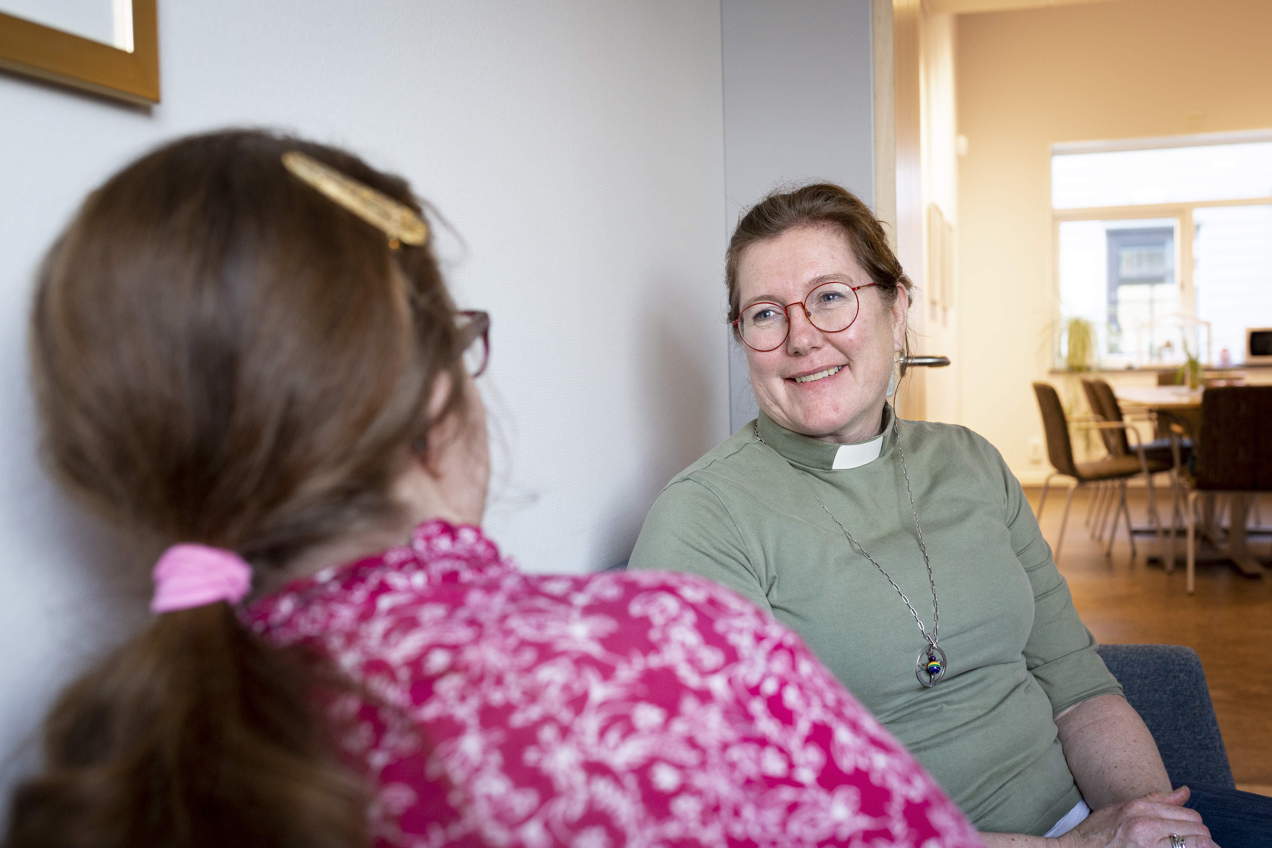 En kvinnlig diakon sitter och samtalar med en en ung tjej.