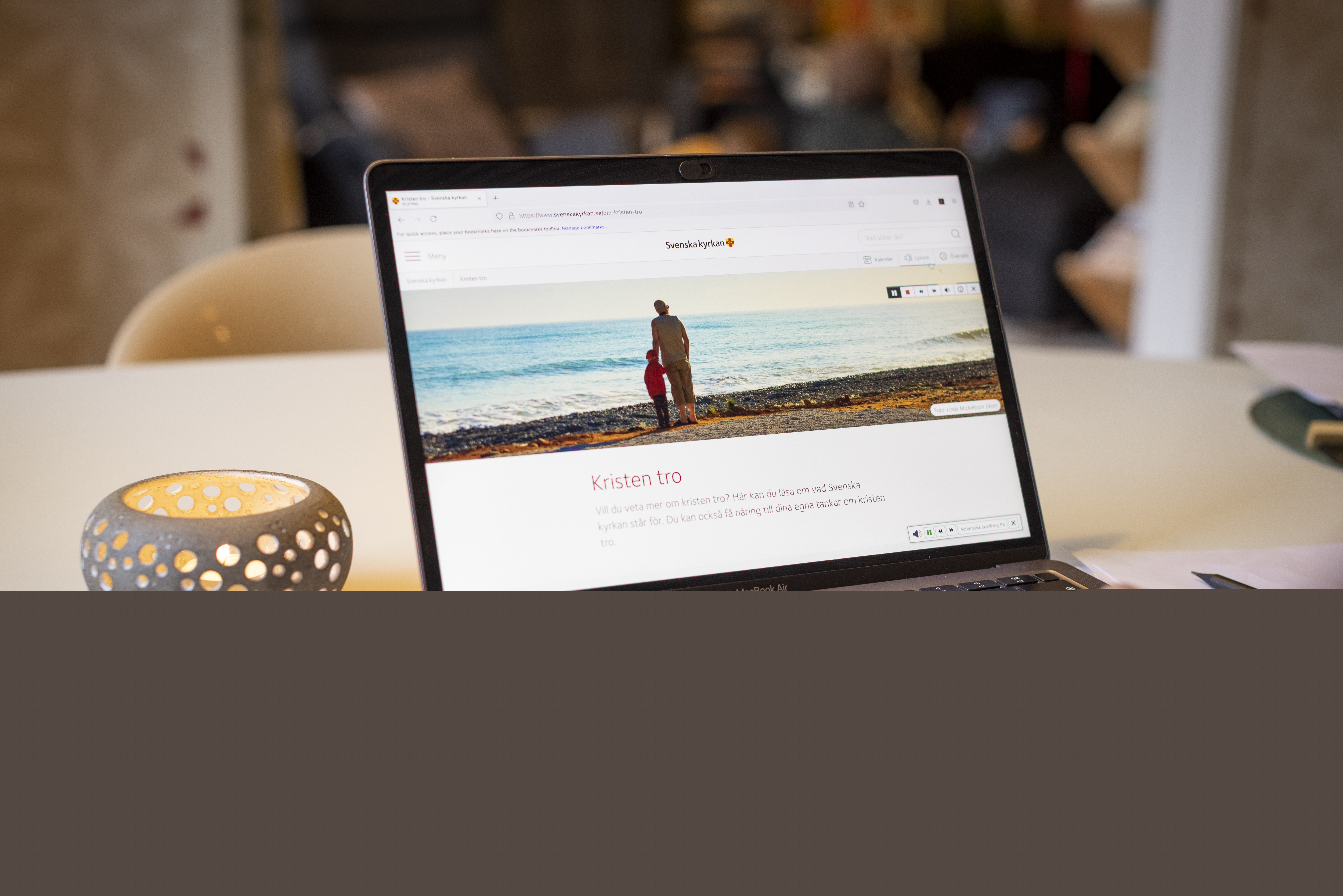 En person sitter vid datorn och läser på Svenska kyrkans webbsida om Kristen tro.