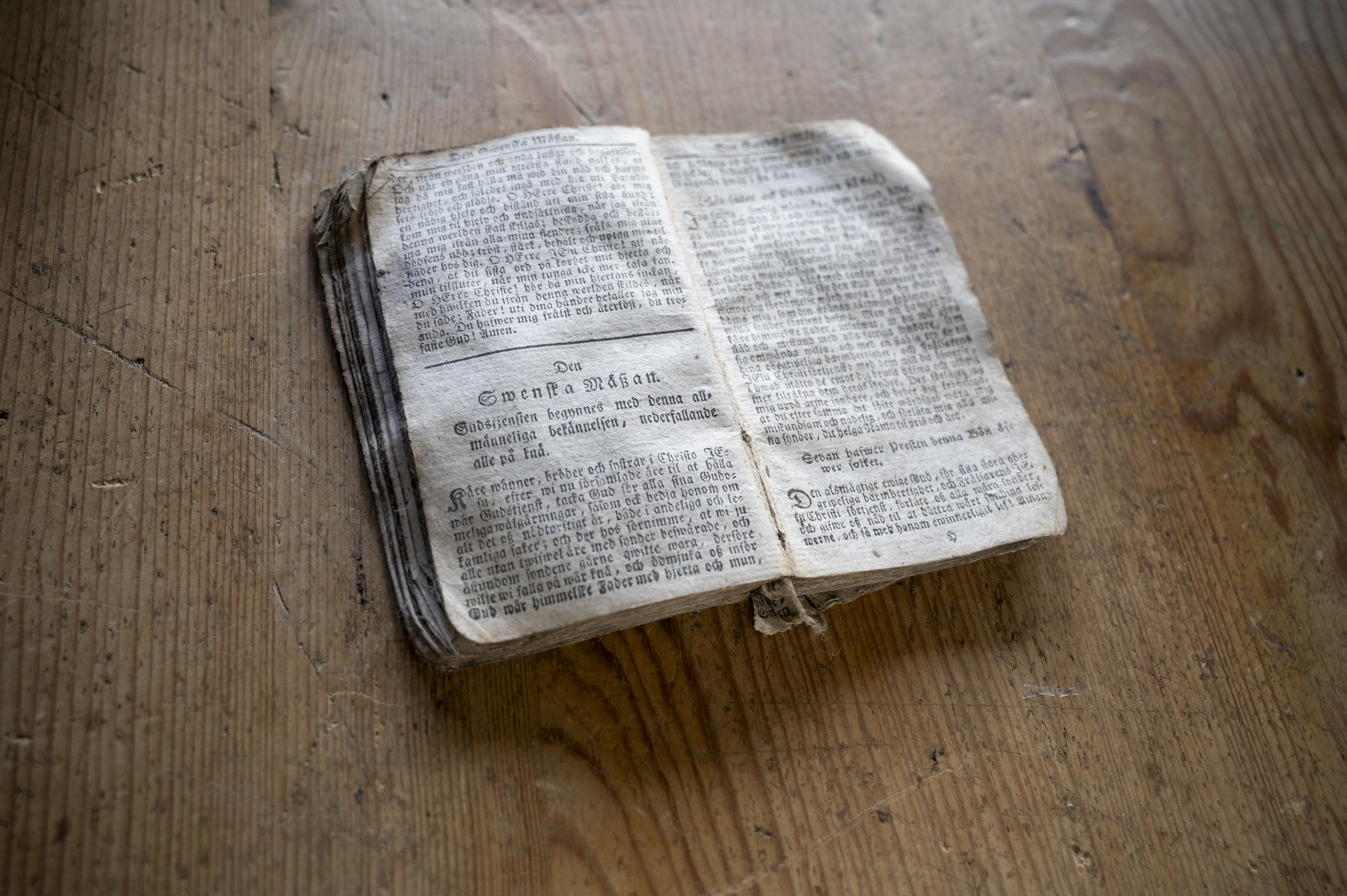 En gammal bok ligger uppslagen på ett bord.