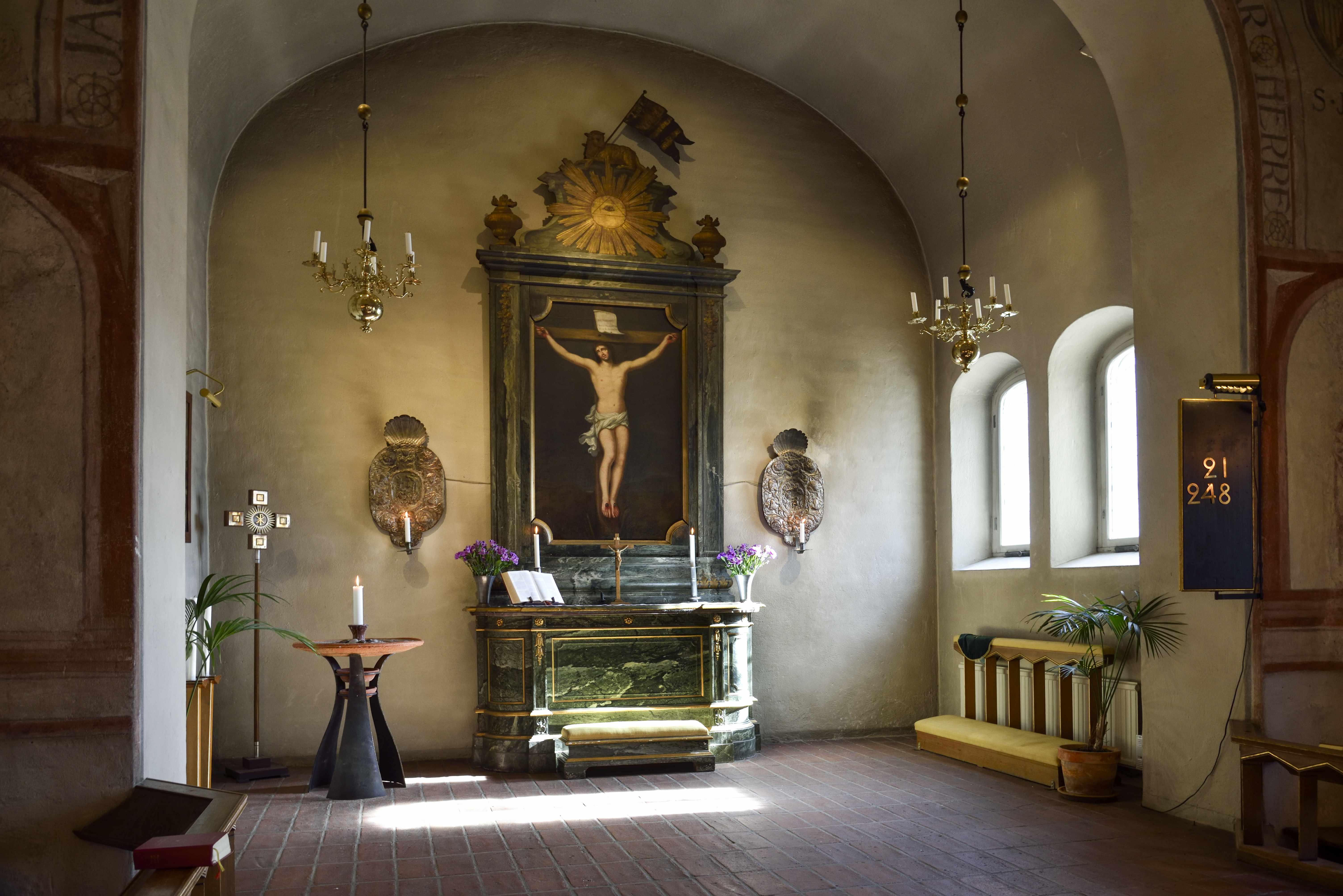 Ett altare med en altartavla som föreställer korsfästelsen.