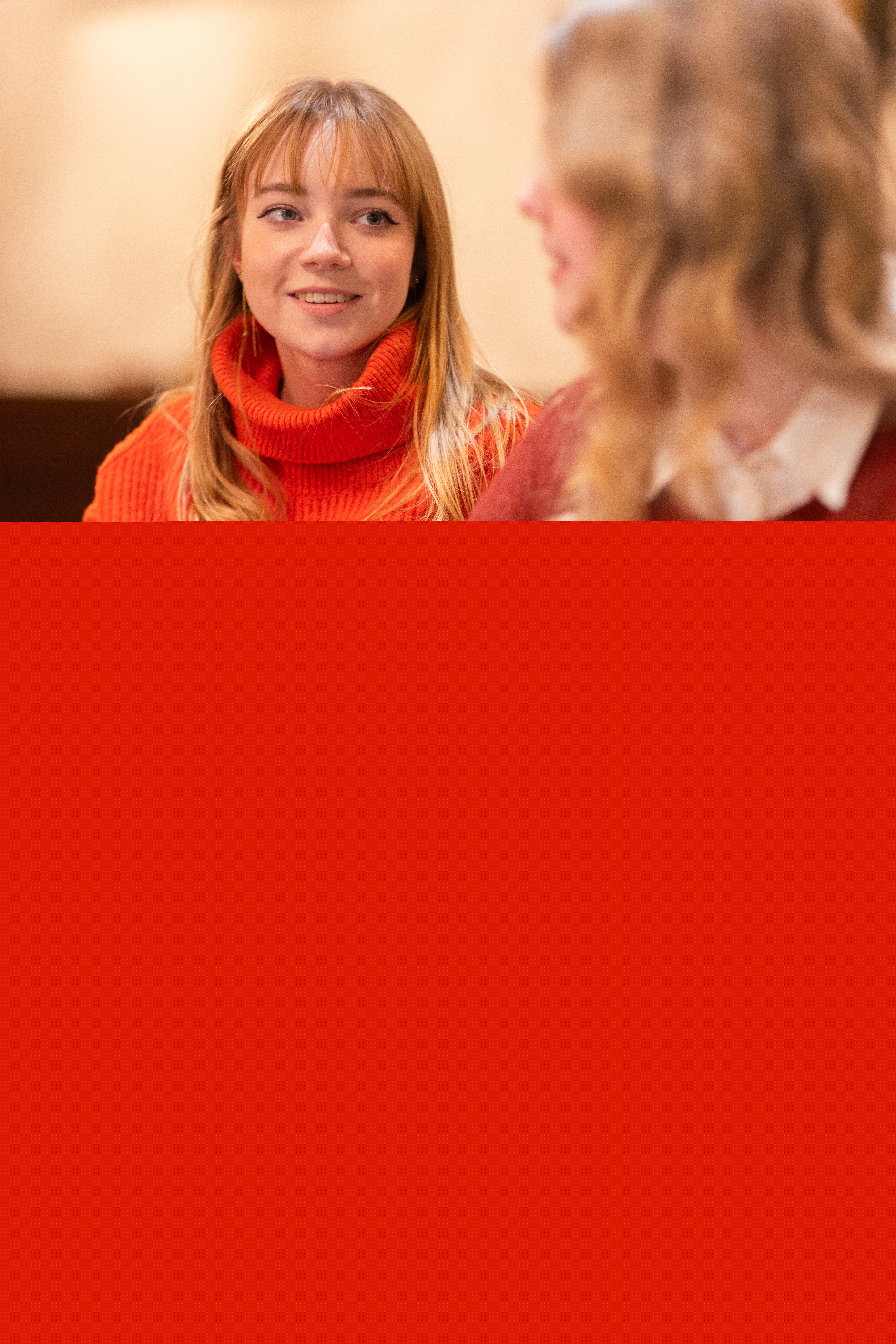 Två unga kvinnor sitter och samtalar.